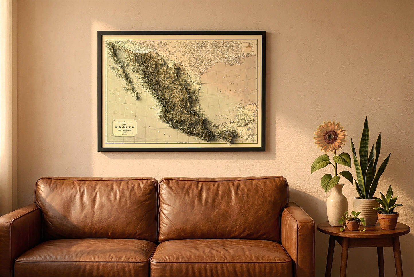 Mexico vintage relief map in a black frame above a brown leather sofa. Boho living room with warm sunlight, sunflower, and indoor plants on a wooden side table