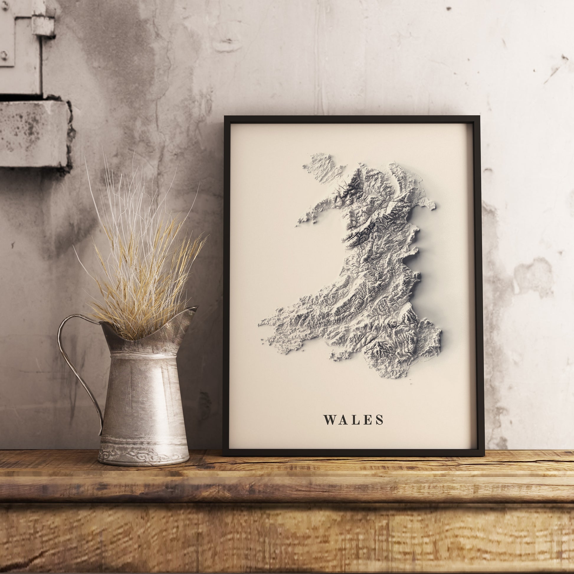 Wales shaded relief map in black frame. Realistic terrain art print for home decor, displayed on rustic wooden table