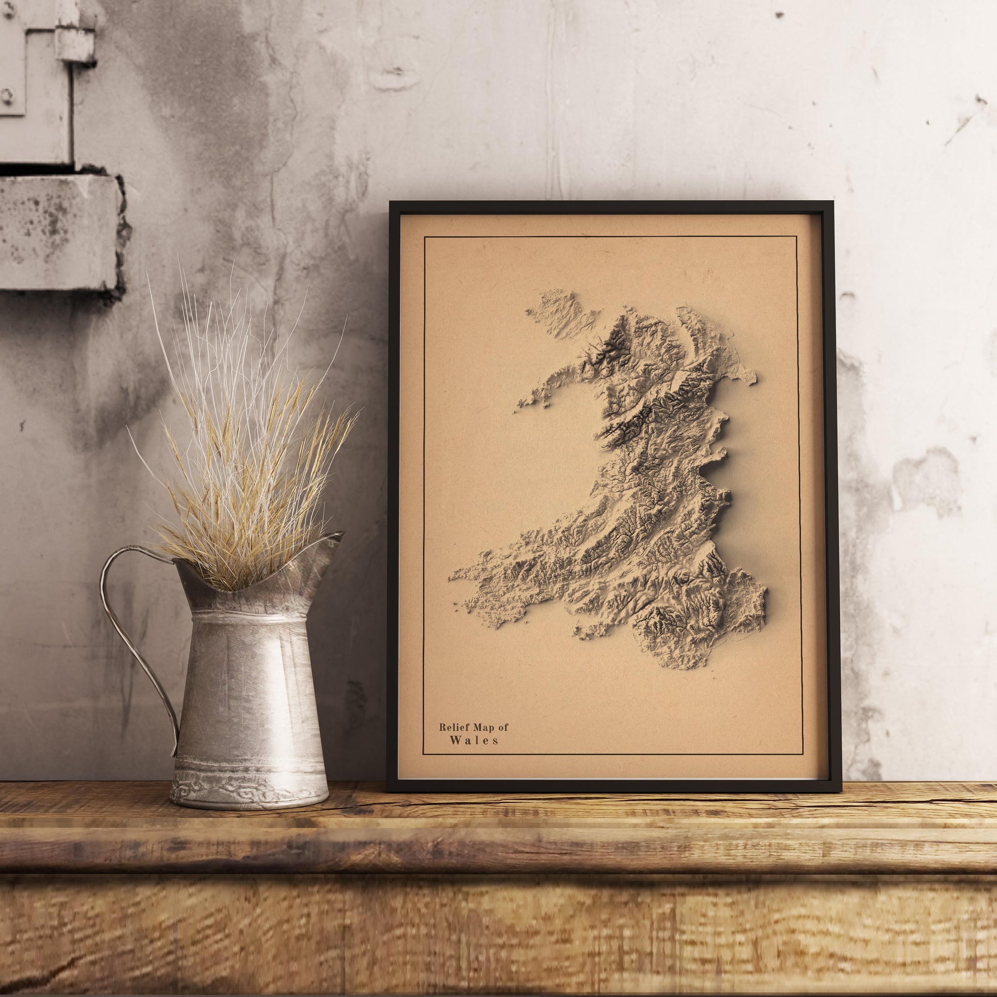 Wales shaded relief map in black frame. Realistic terrain art print for home decor, displayed on rustic wooden table