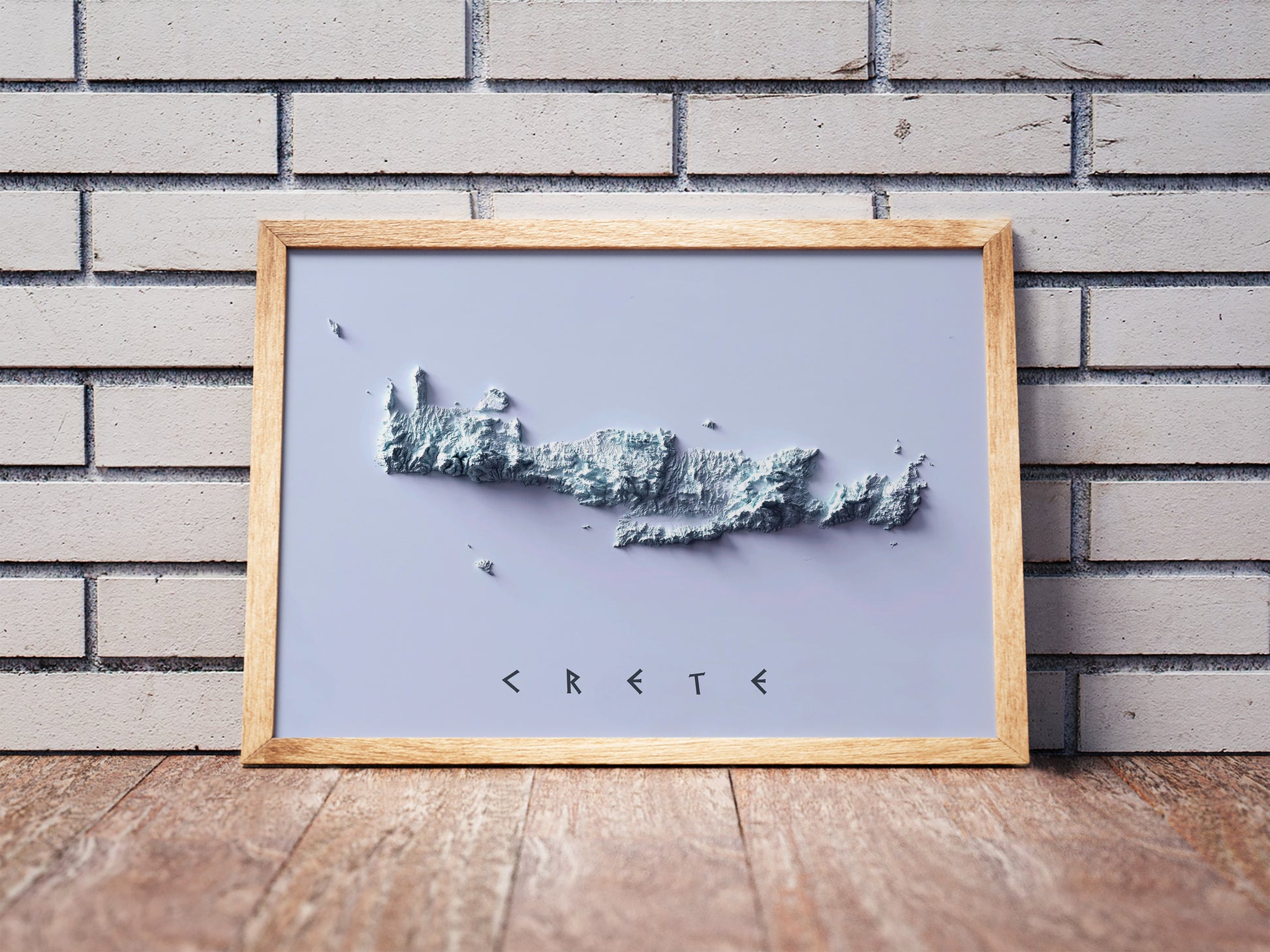 Crete, Greece, shaded relief map in a wooden frame. Realistic terrain art print for home decor, displayed against a brick wall