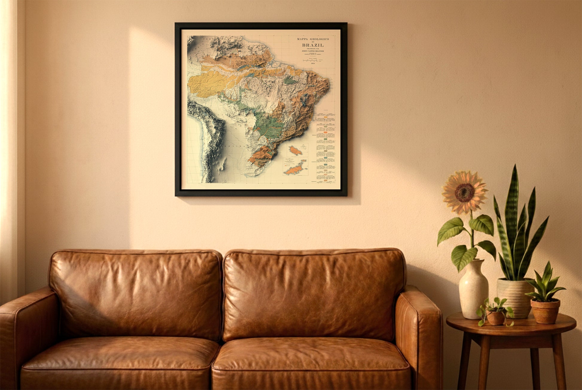 Brazil vintage relief map in a black frame above a brown leather sofa. Boho living room with warm sunlight, sunflower, and indoor plants on a wooden side table