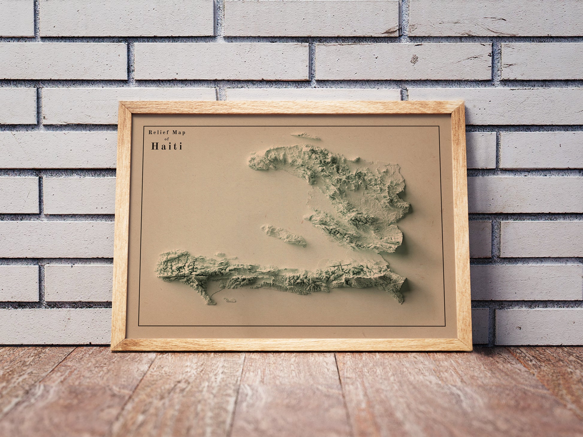 Vintage Haiti shaded relief map in a wooden frame. Realistic terrain art print for home decor, displayed against a brick wall