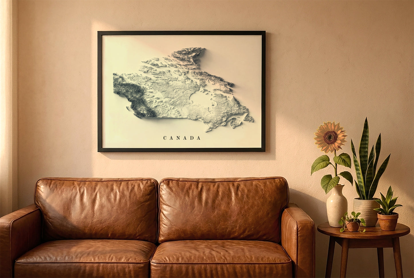 Canada relief map in a black frame above a brown leather sofa. Boho living room with warm sunlight, sunflower, and indoor plants on a wooden side table