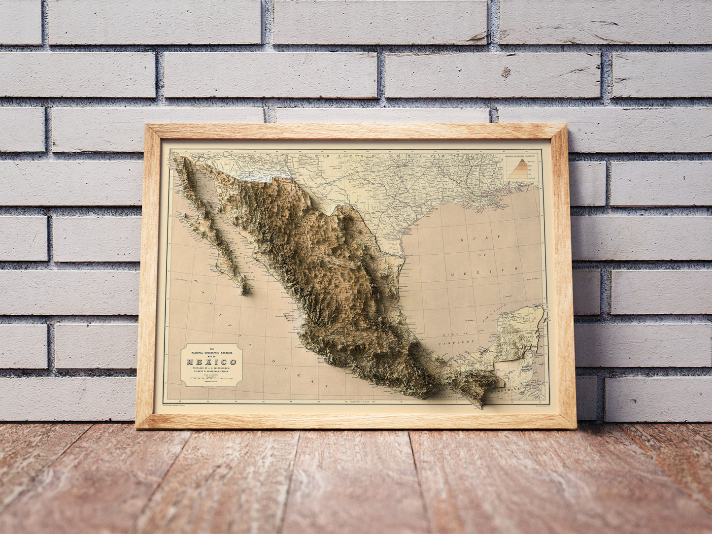 Vintage Mexico shaded relief map in a wooden frame. Realistic terrain art print for home decor, displayed against a brick wall