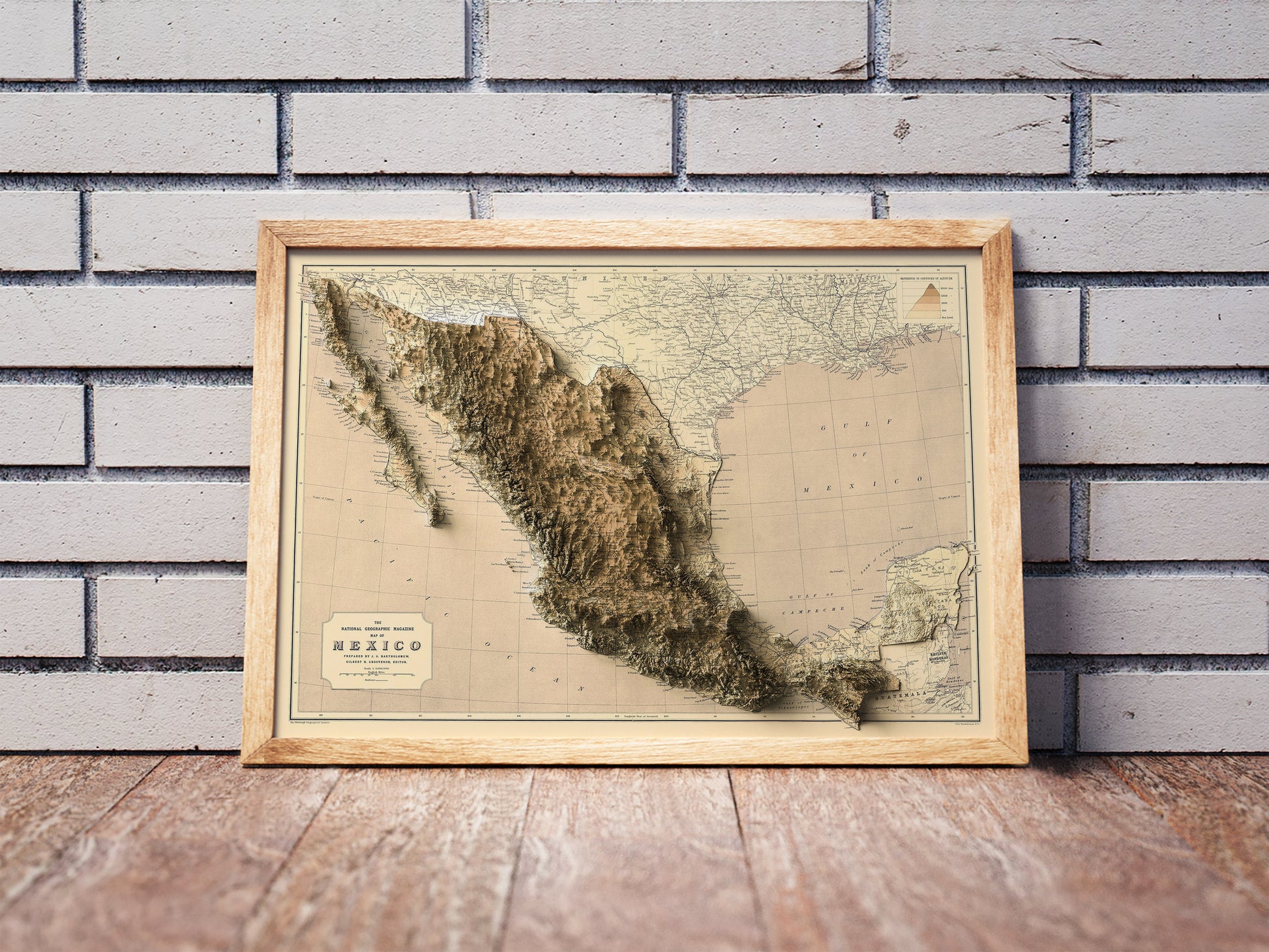 Vintage Mexico shaded relief map in a wooden frame. Realistic terrain art print for home decor, displayed against a brick wall