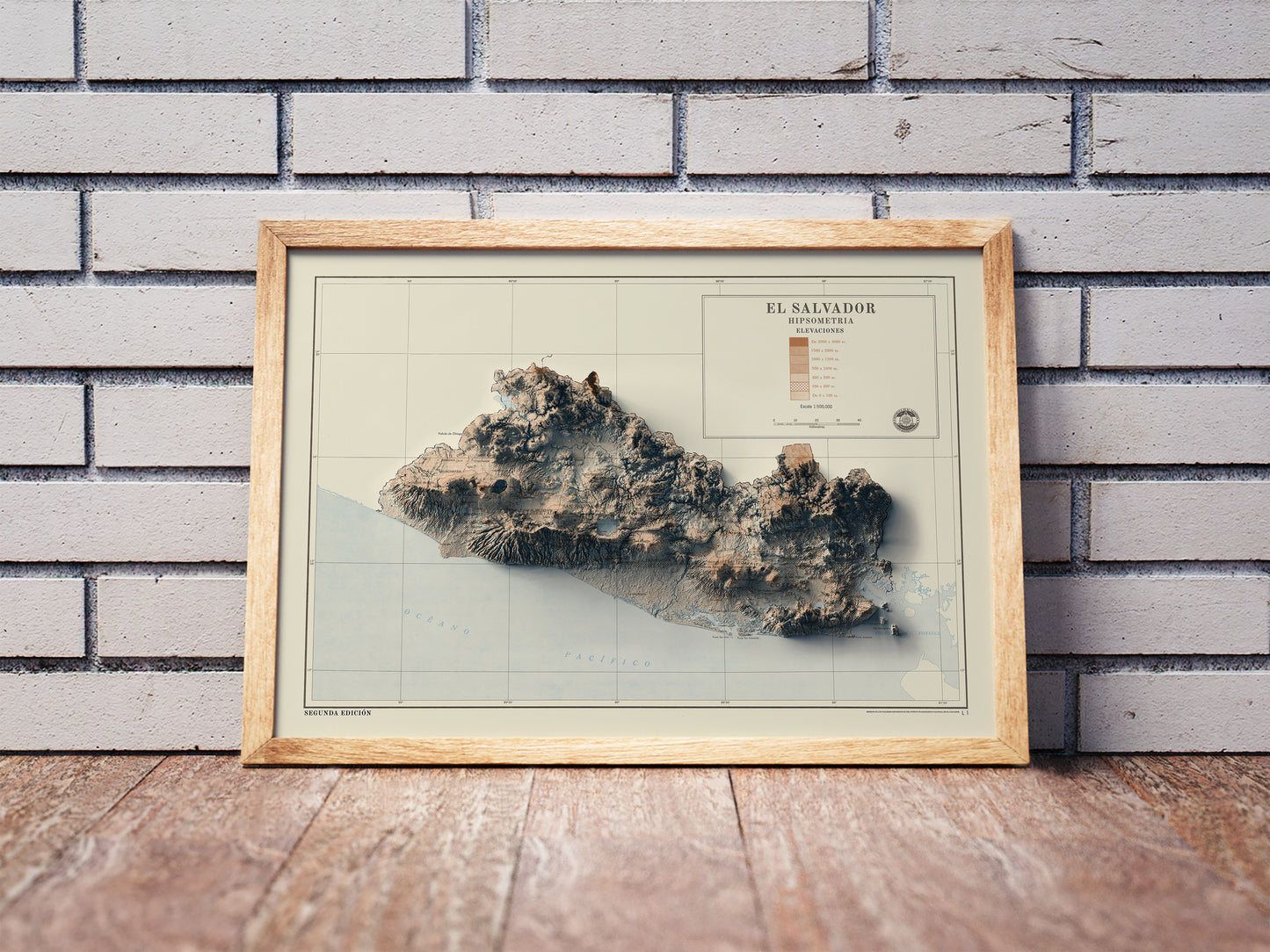 Vintage El Salvador shaded relief map in a wooden frame. Realistic terrain art print for home decor, displayed against a brick wall