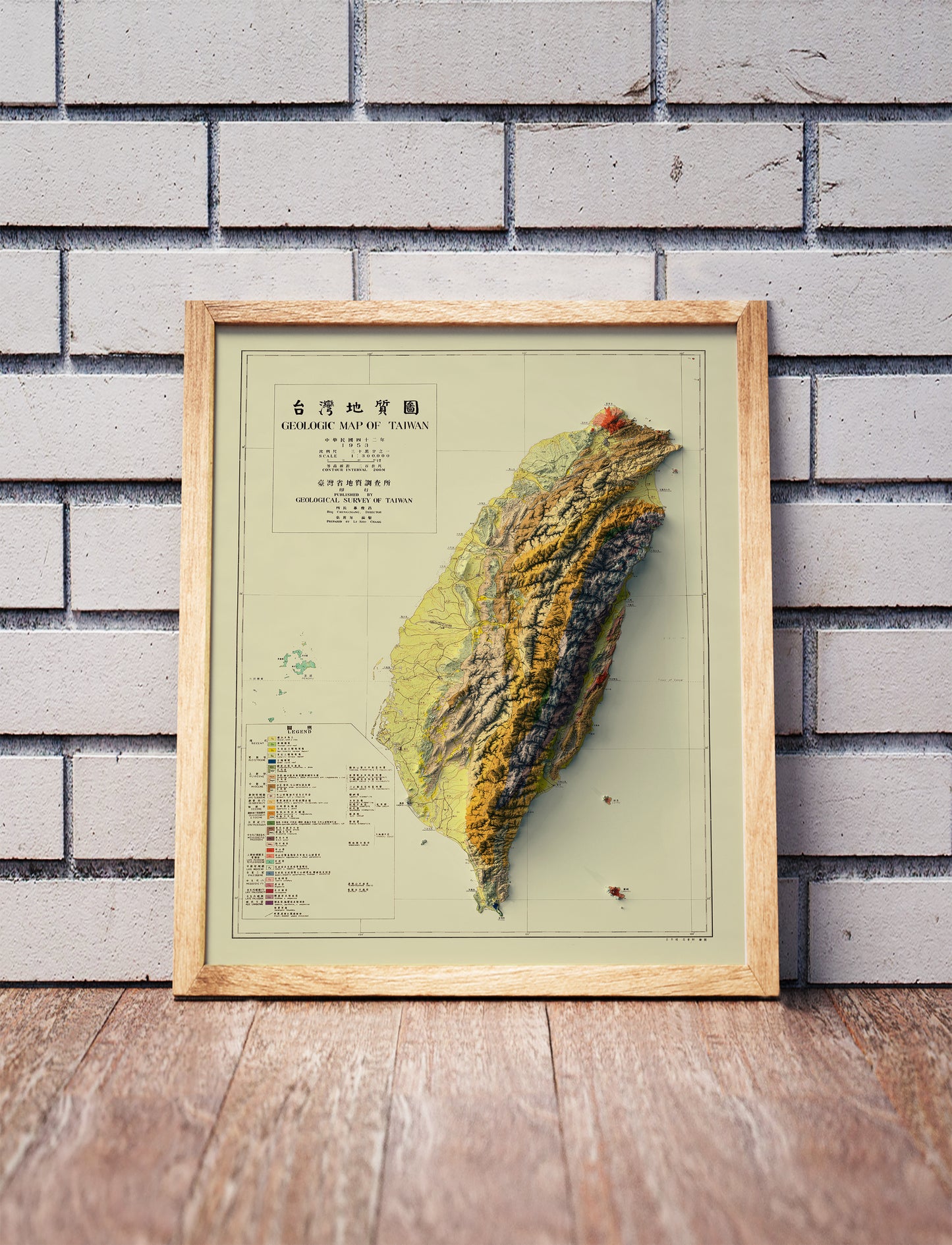 Vintage Taiwan shaded relief map in a wooden frame. Realistic terrain art print for home decor, displayed against a brick wall