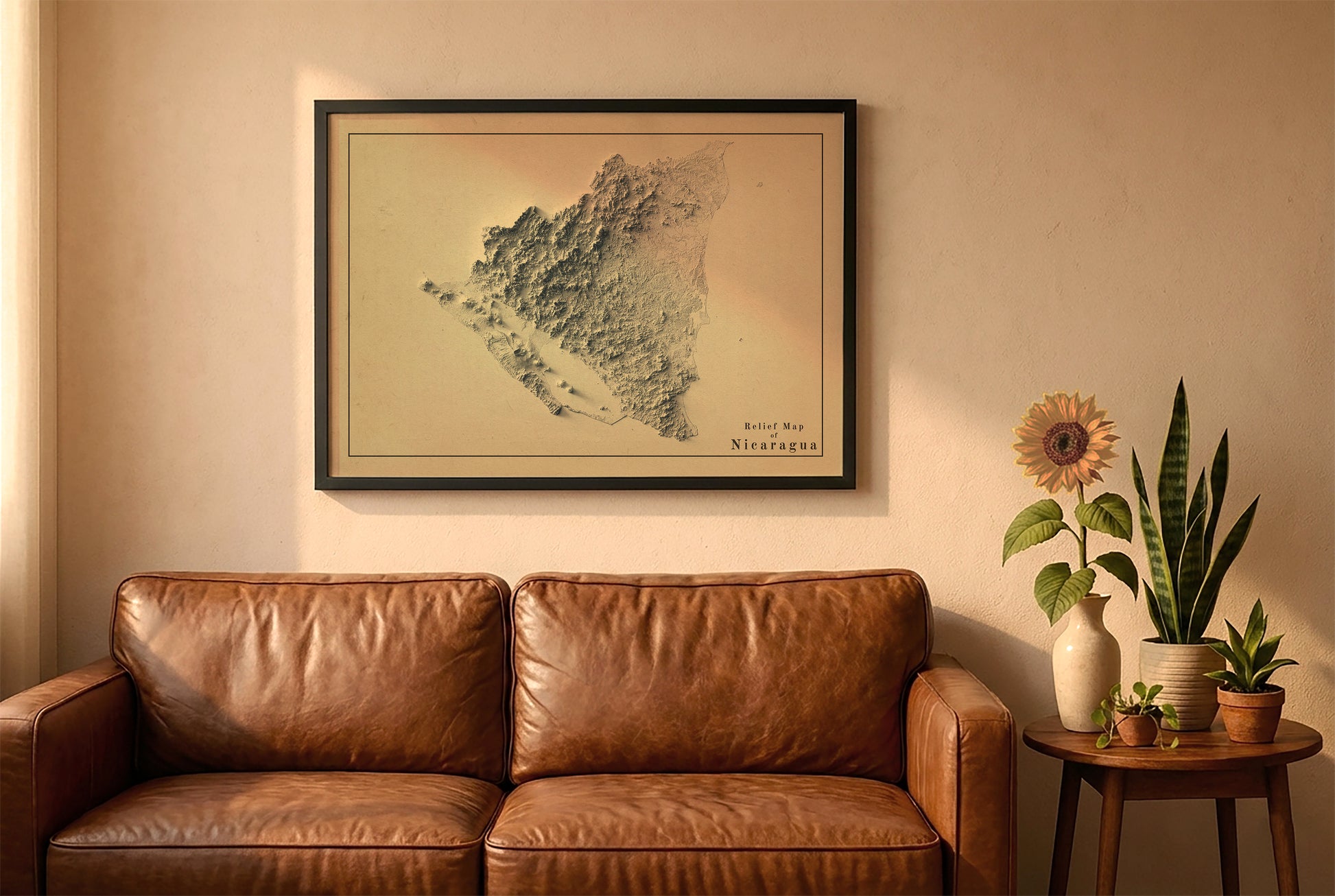 Nicaragua vintage relief map in a black frame above a brown leather sofa. Boho living room with warm sunlight, sunflower, and indoor plants on a wooden side table