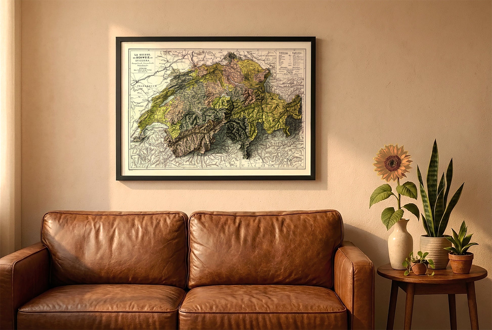 Switzerland vintage relief map in a black frame above a brown leather sofa. Boho living room with warm sunlight, sunflower, and indoor plants on a wooden side table