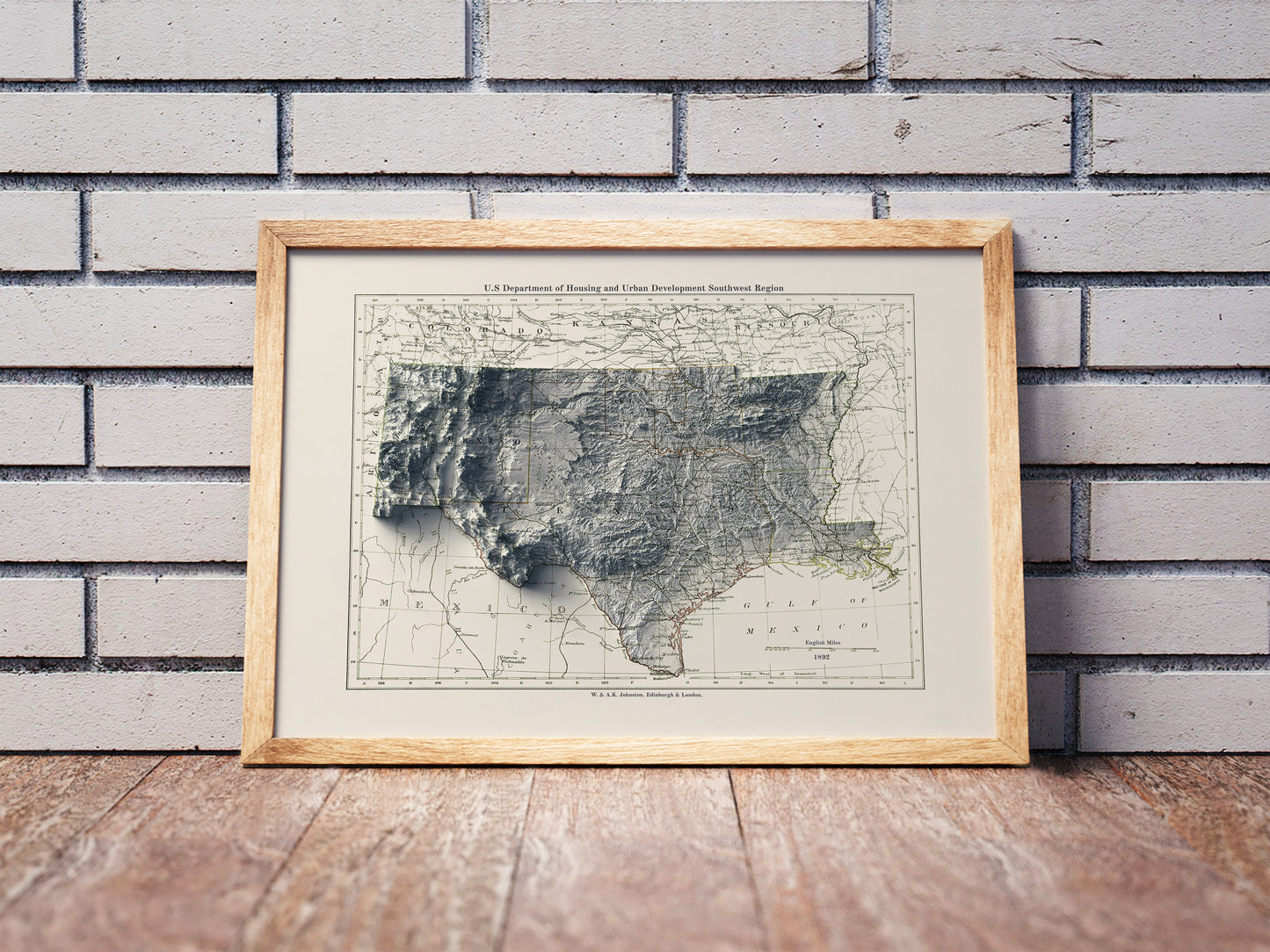 Vintage South Central USA shaded relief map in a wooden frame. Realistic terrain art print for home decor, displayed against a brick wall