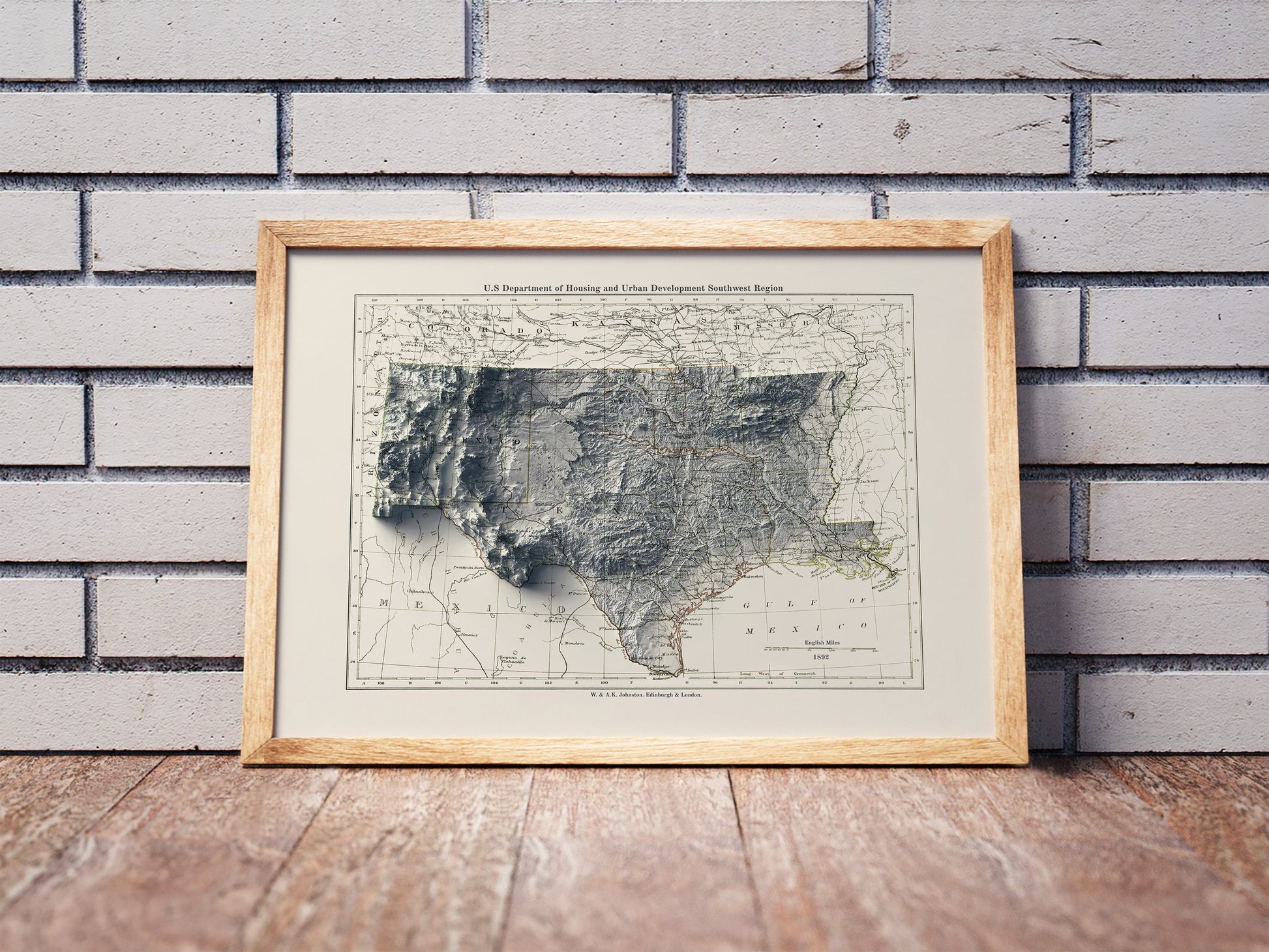Vintage South Central USA shaded relief map in a wooden frame. Realistic terrain art print for home decor, displayed against a brick wall