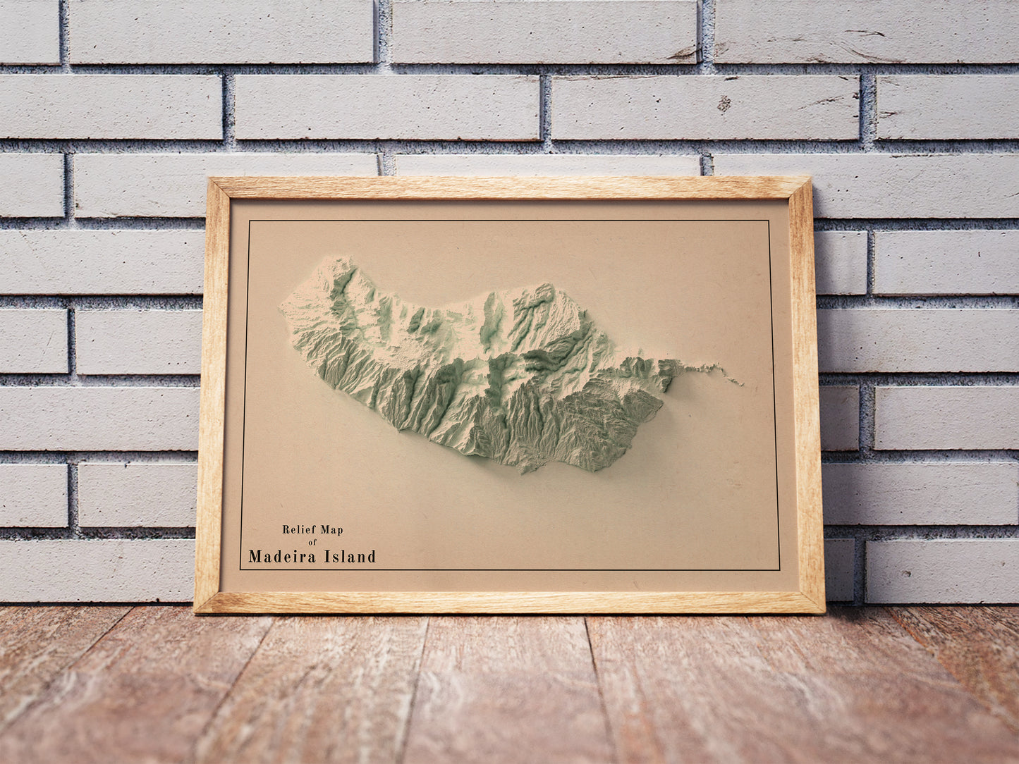 Vintage Madeira Island, Portugal, shaded relief map in a wooden frame. Realistic terrain art print for home decor, displayed against a brick wall