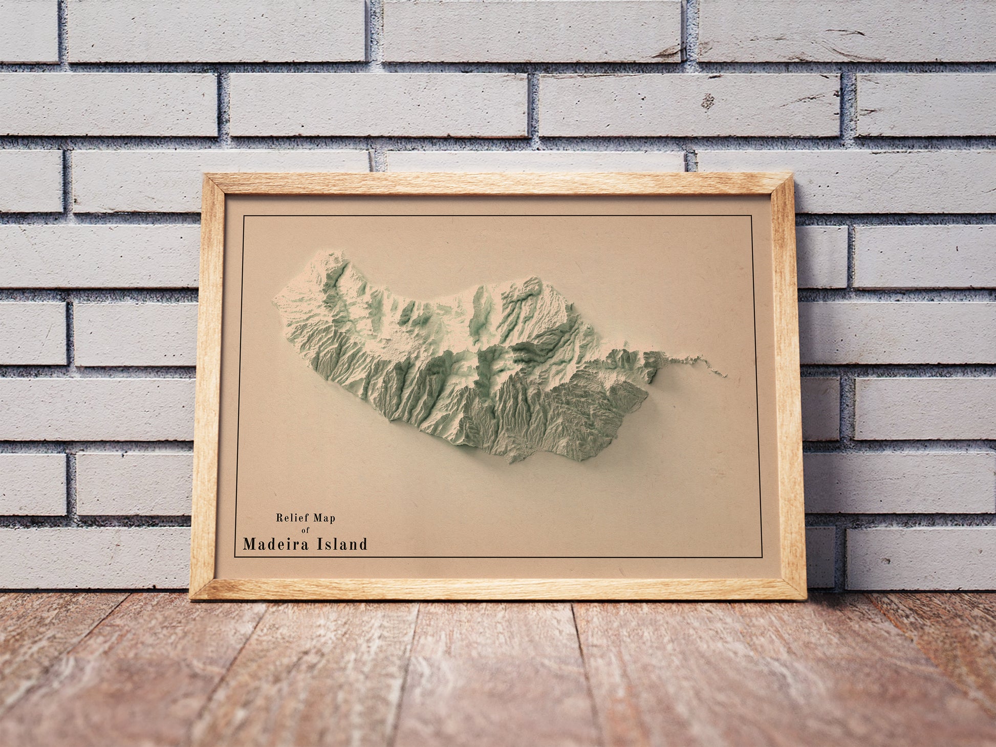 Vintage Madeira Island, Portugal, shaded relief map in a wooden frame. Realistic terrain art print for home decor, displayed against a brick wall