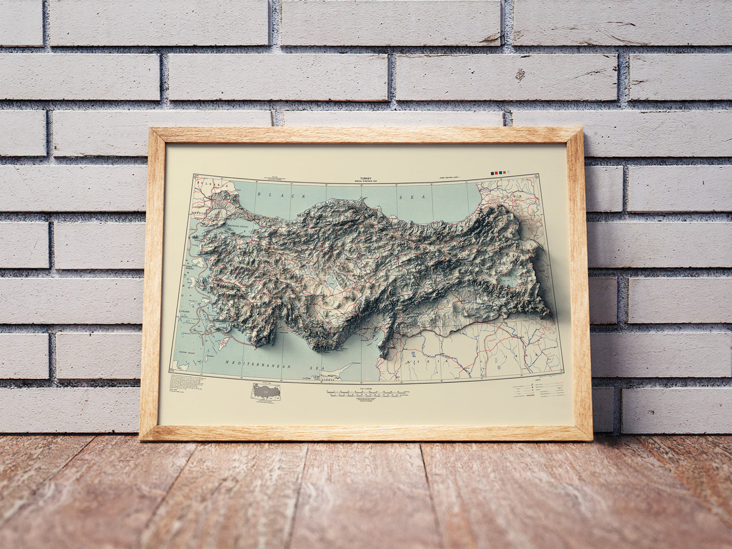 Vintage Turkey shaded relief map in a wooden frame. Realistic terrain art print for home decor, displayed against a brick wall
