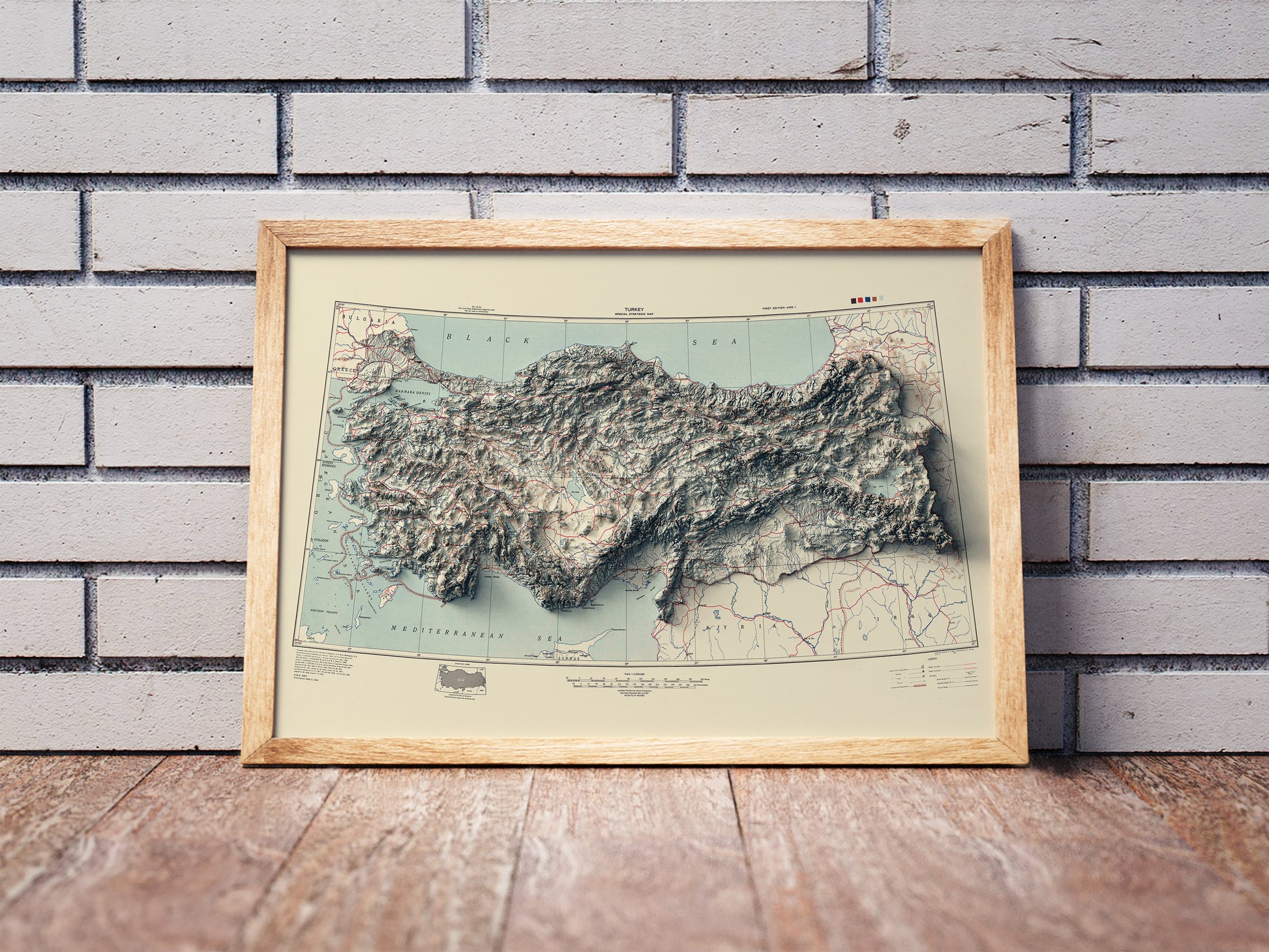 Vintage Turkey shaded relief map in a wooden frame. Realistic terrain art print for home decor, displayed against a brick wall