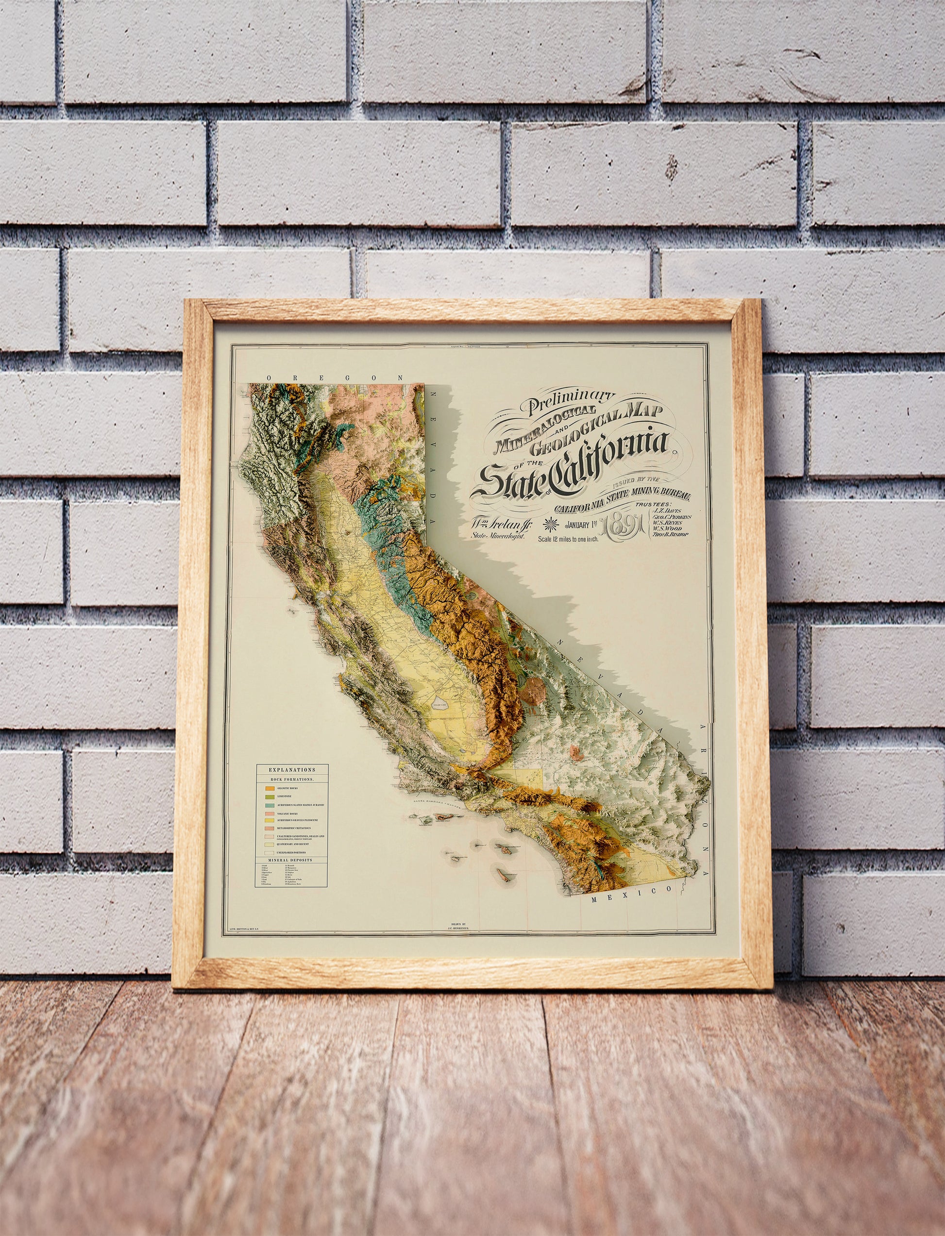 Vintage California shaded relief map in a wooden frame. Realistic terrain art print for home decor, displayed against a brick wall
