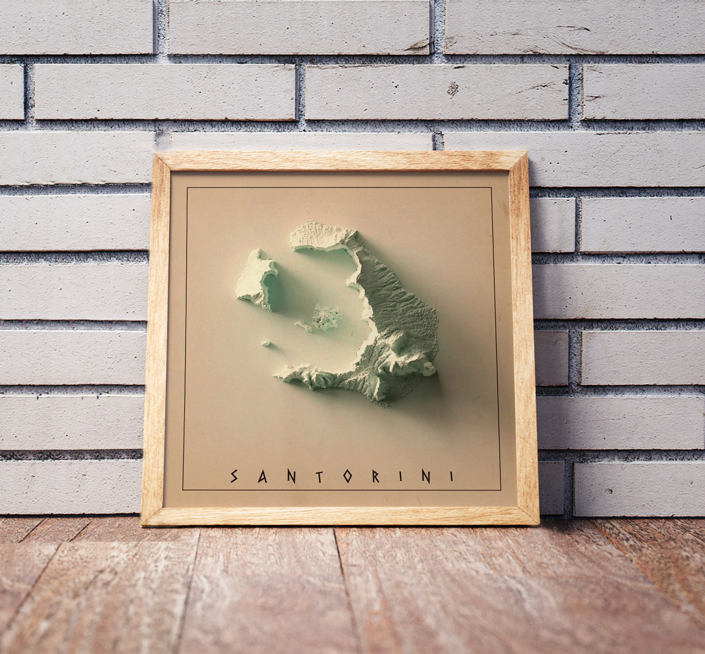 Vintage Santorini, Greece, shaded relief map in a wooden frame. Realistic terrain art print for home decor, displayed against a brick wall