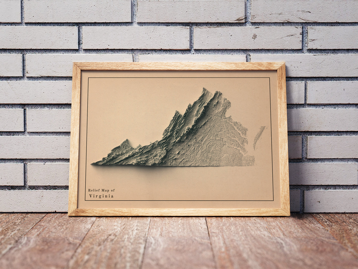 Vintage Virginia shaded relief map in a wooden frame. Realistic terrain art print for home decor, displayed against a brick wall