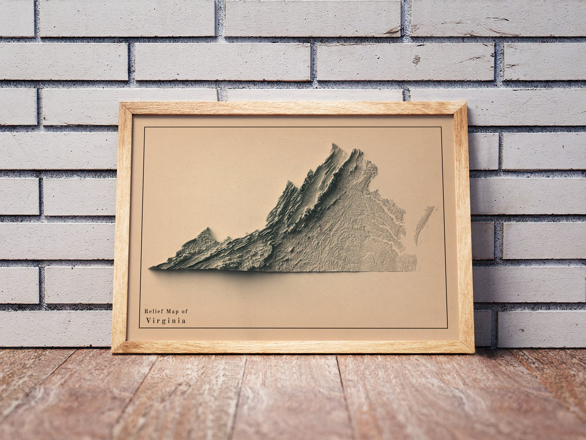 Vintage Virginia shaded relief map in a wooden frame. Realistic terrain art print for home decor, displayed against a brick wall