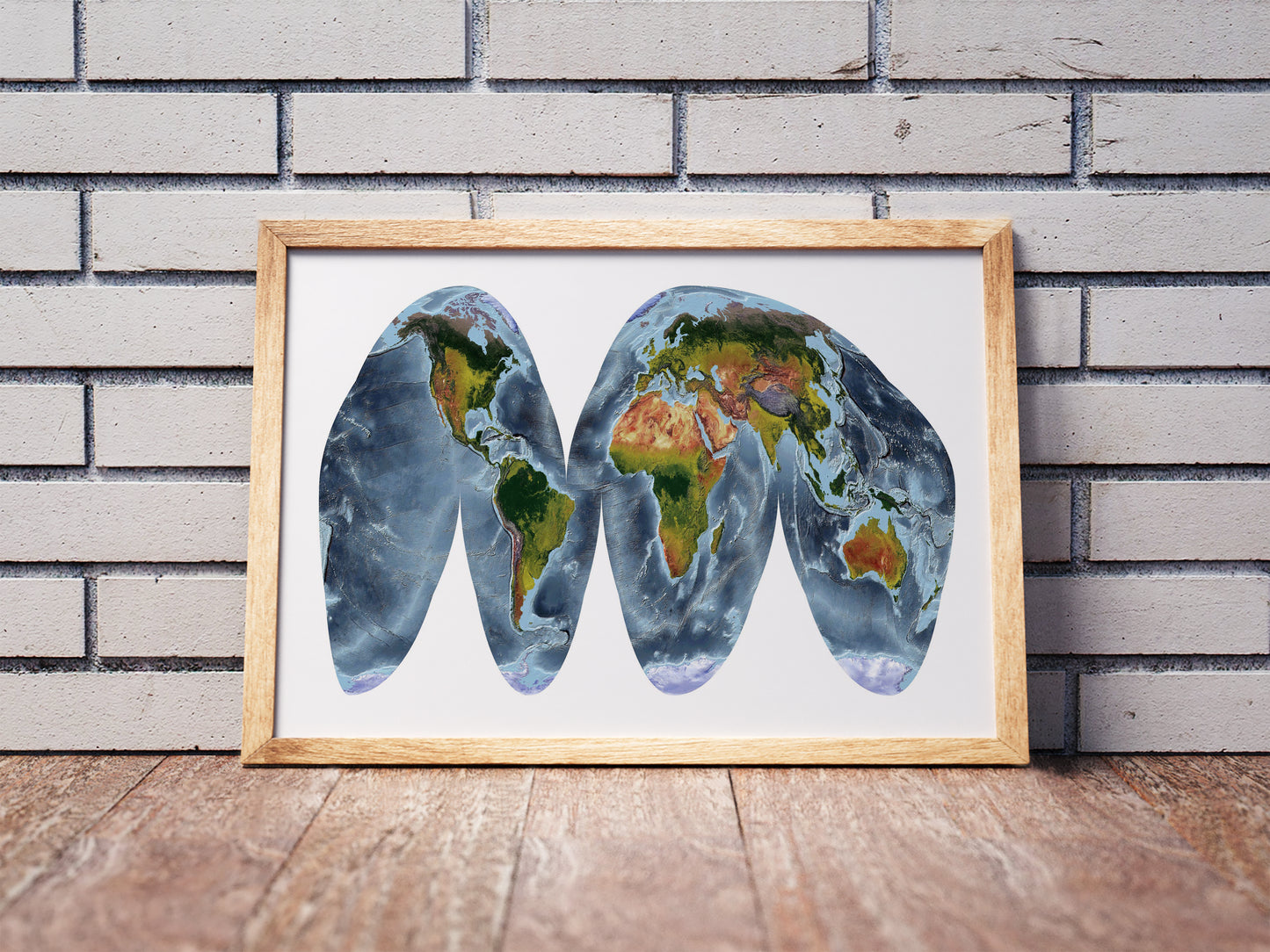 Goode Homolosine Land projection shaded relief world map in a wooden frame. Realistic terrain art print for home decor, displayed against a brick wall