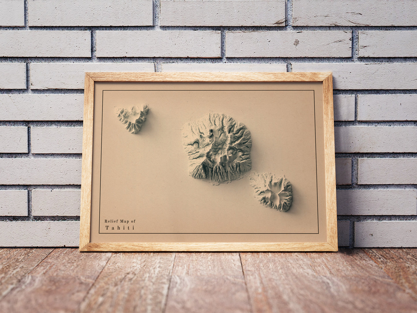 Vintage Tahiti shaded relief map in a wooden frame. Realistic terrain art print for home decor, displayed against a brick wall