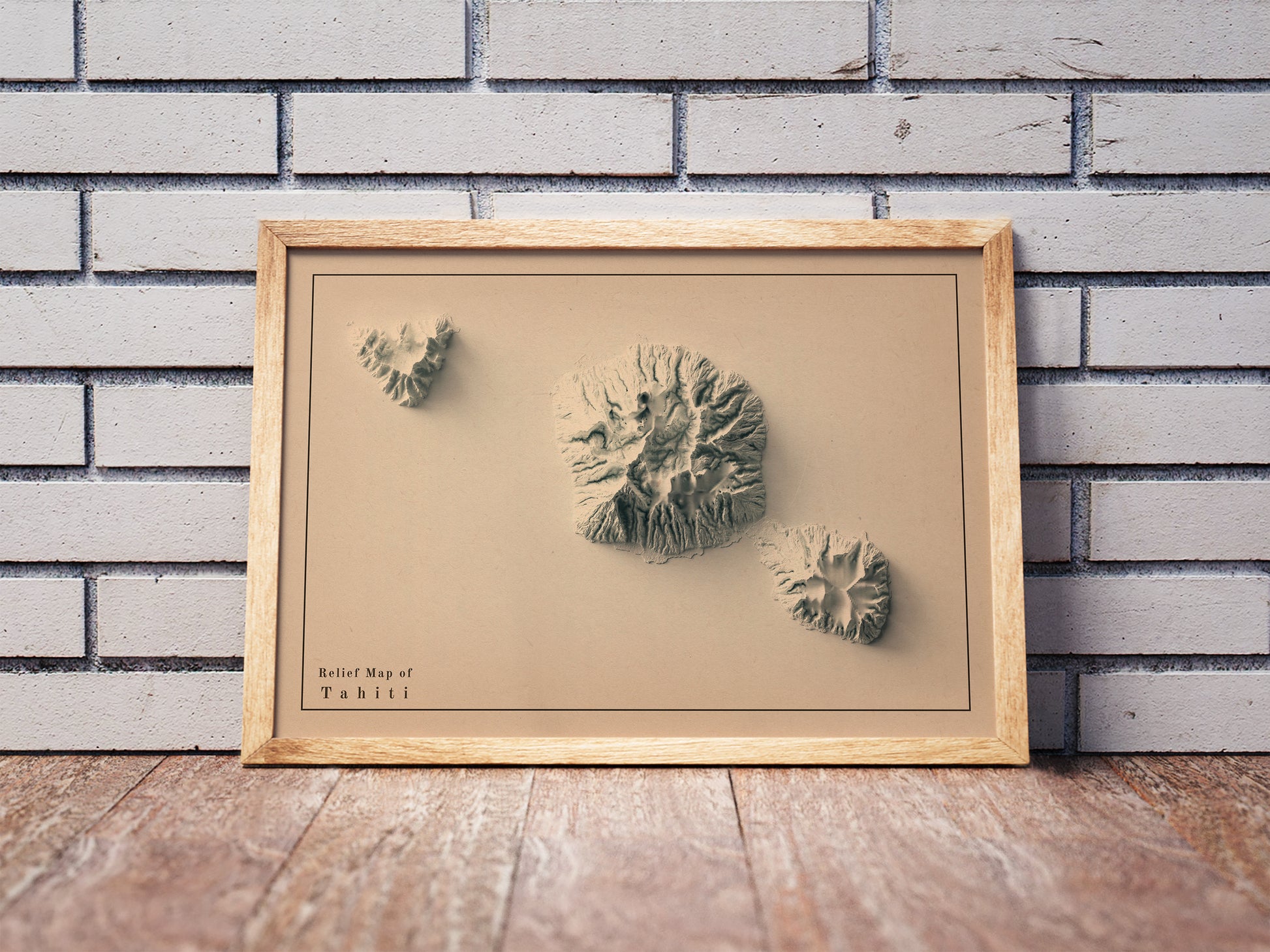 Vintage Tahiti shaded relief map in a wooden frame. Realistic terrain art print for home decor, displayed against a brick wall