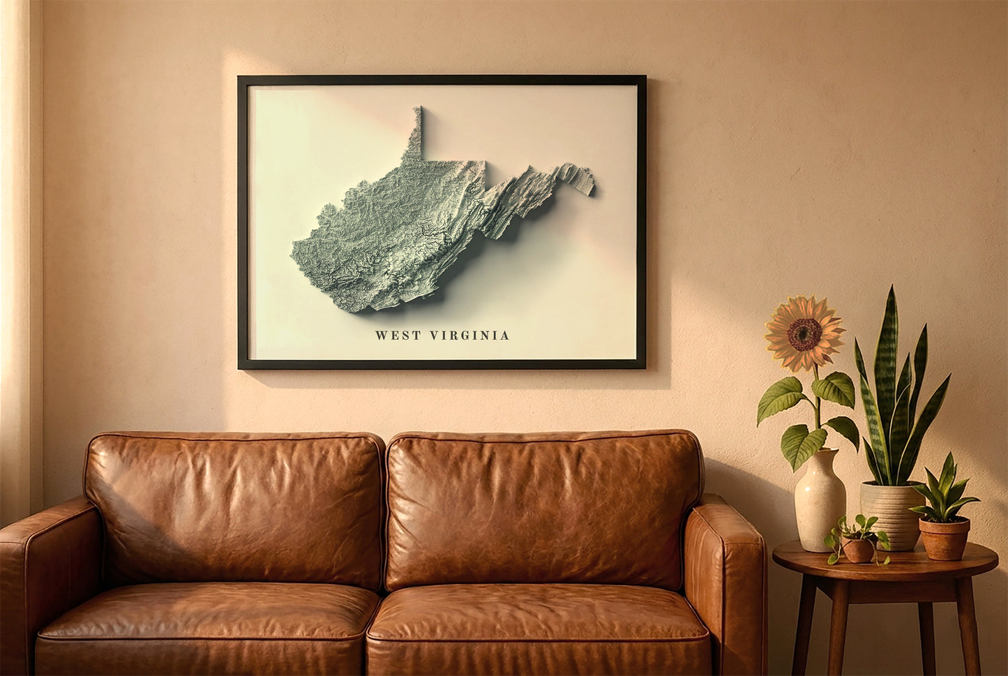 West Virginia relief map in a black frame above a brown leather sofa. Boho living room with warm sunlight, sunflower, and indoor plants on a wooden side table