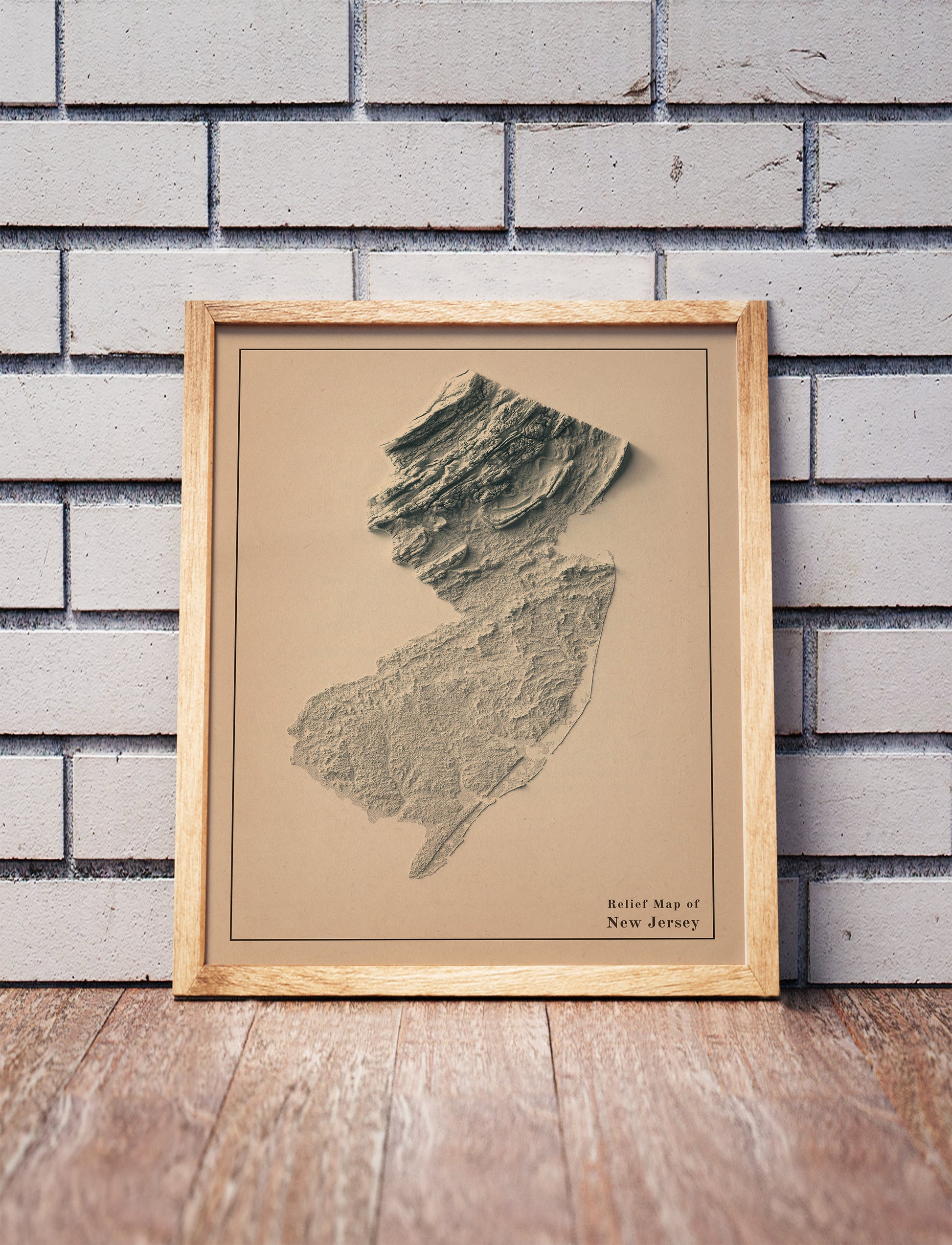 Vintage New Jersey shaded relief map in a wooden frame. Realistic terrain art print for home decor, displayed against a brick wall