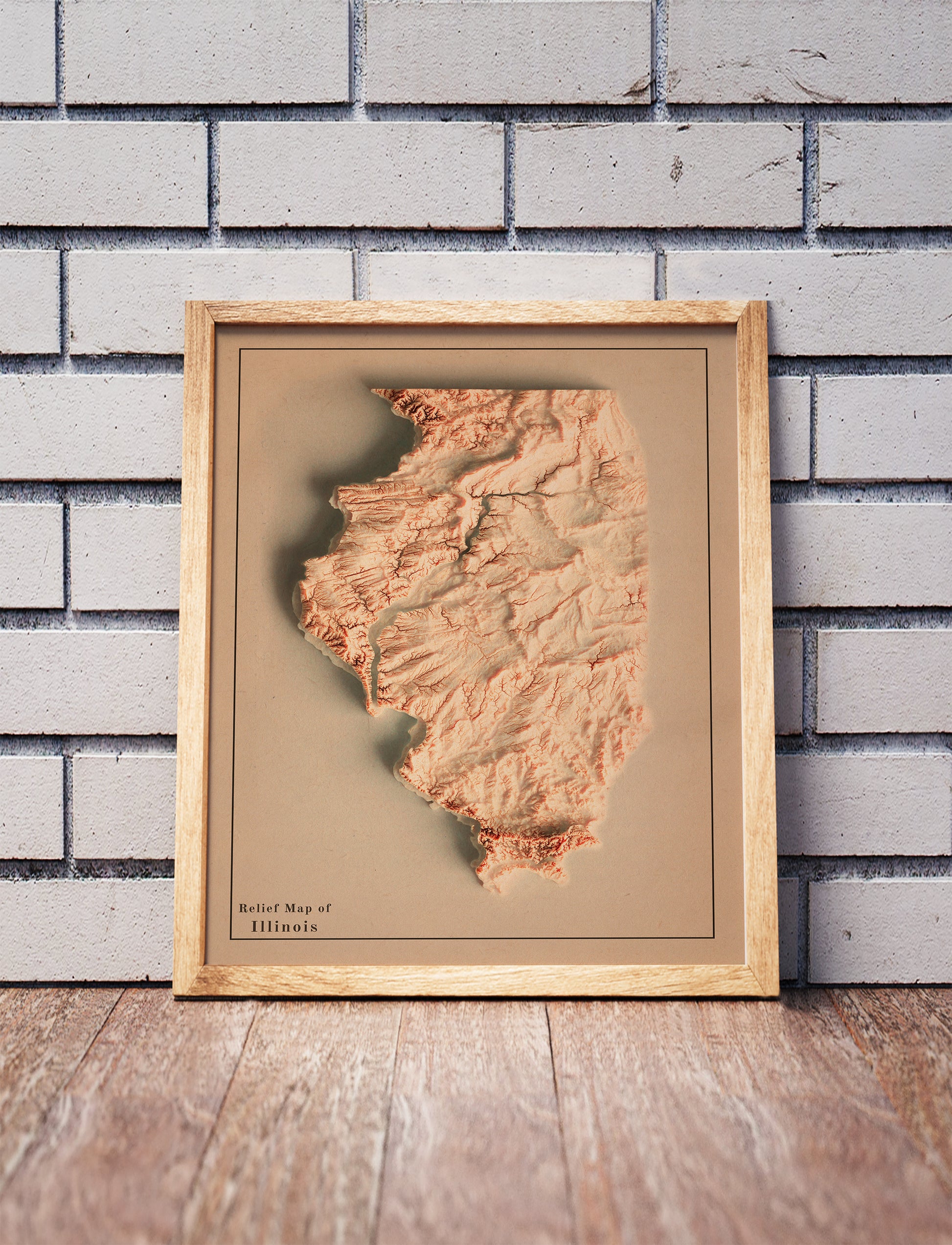Vintage Illinois shaded relief map in a wooden frame. Realistic terrain art print for home decor, displayed against a brick wall
