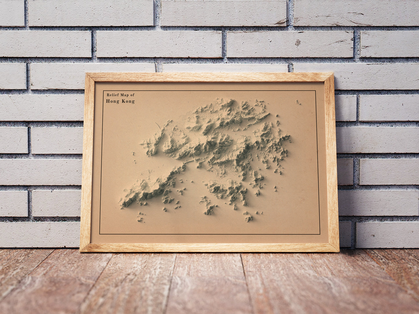 Vintage Hong Kong shaded relief map in a wooden frame. Realistic terrain art print for home decor, displayed against a brick wall