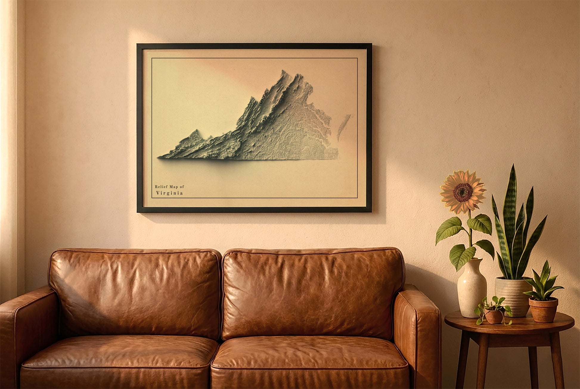 Virginia vintage relief map in a black frame above a brown leather sofa. Boho living room with warm sunlight, sunflower, and indoor plants on a wooden side table