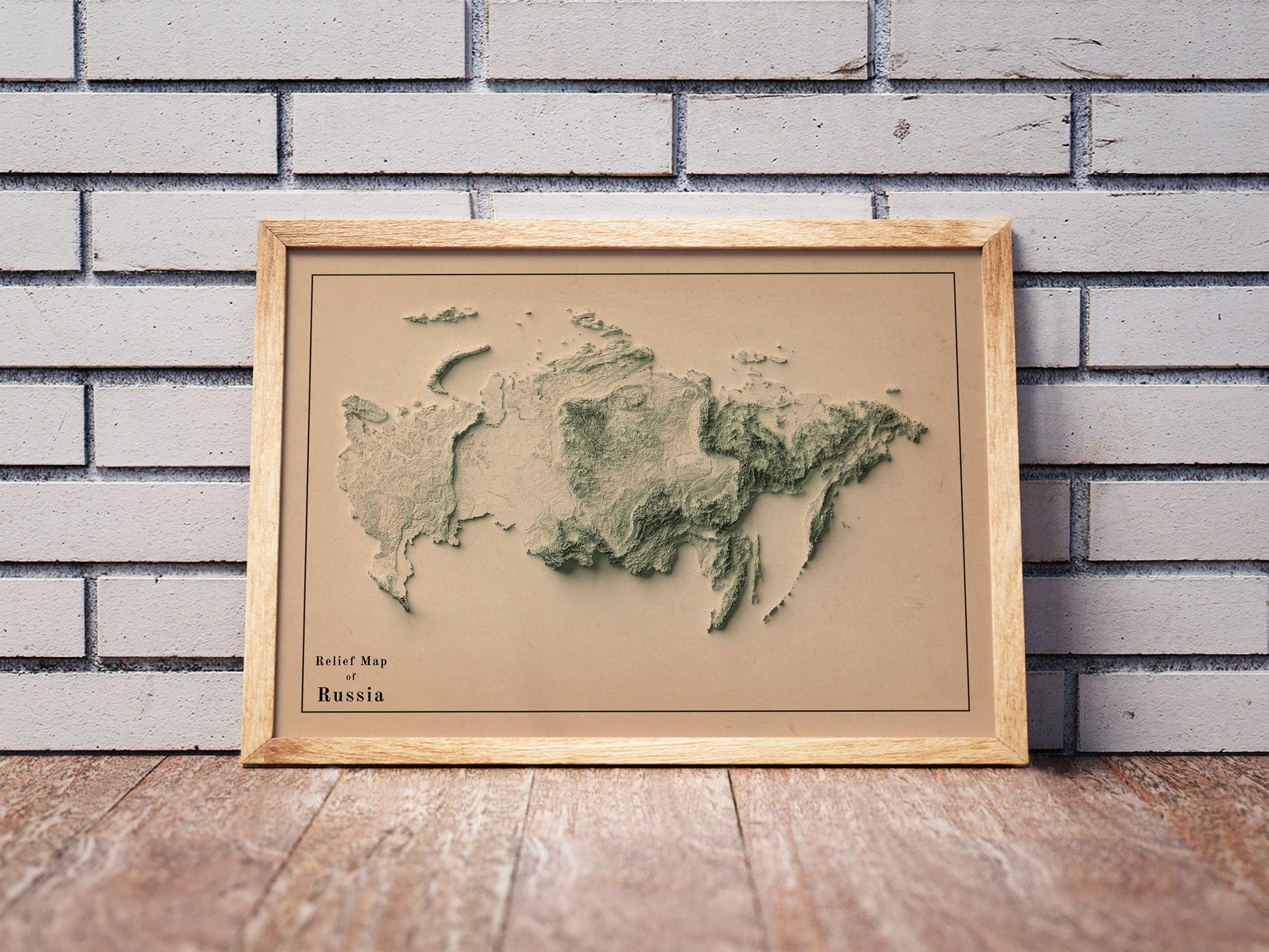 Vintage Russia shaded relief map in a wooden frame. Realistic terrain art print for home decor, displayed against a brick wall