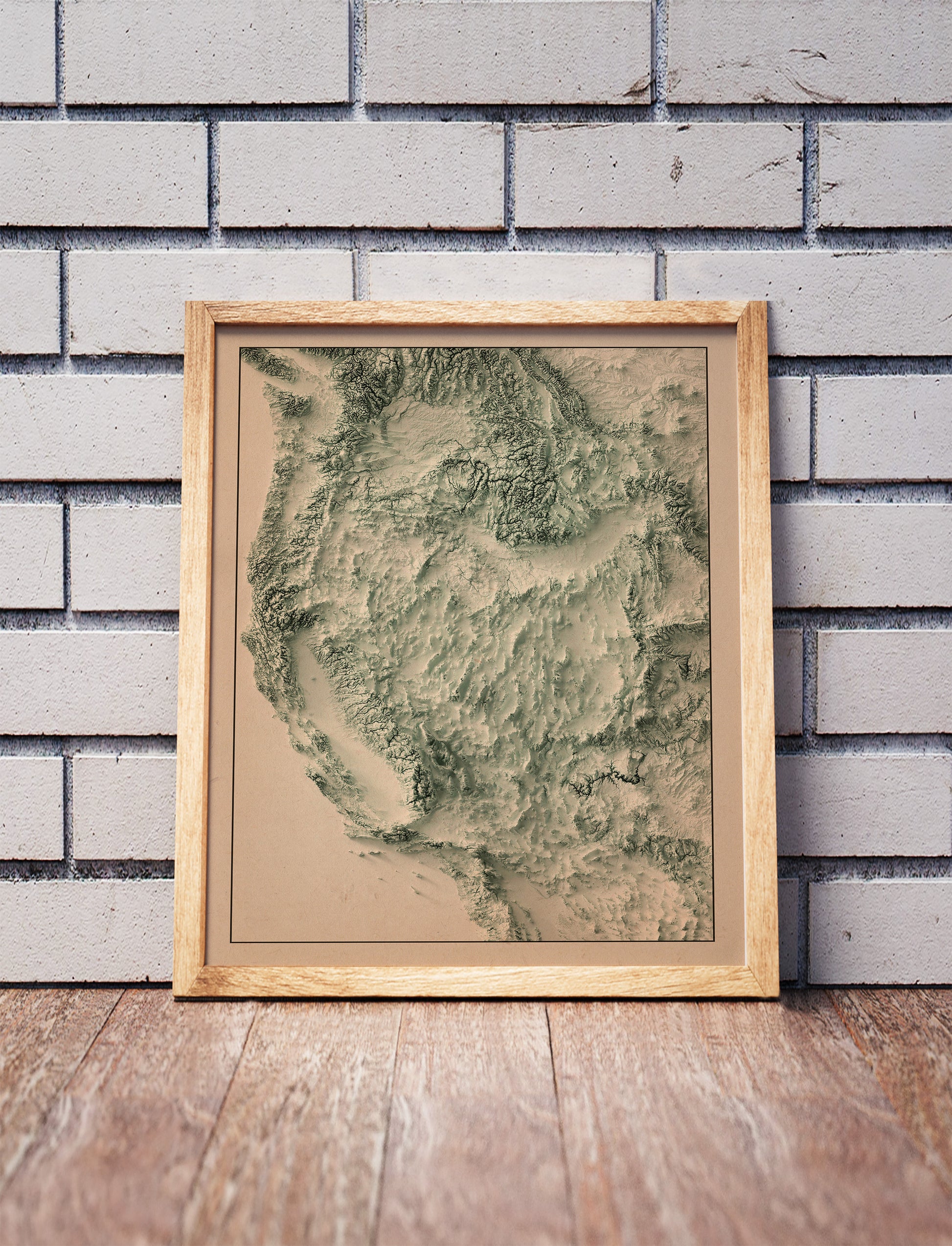Vintage Western USA shaded relief map in a wooden frame. Realistic terrain art print for home decor, displayed against a brick wall