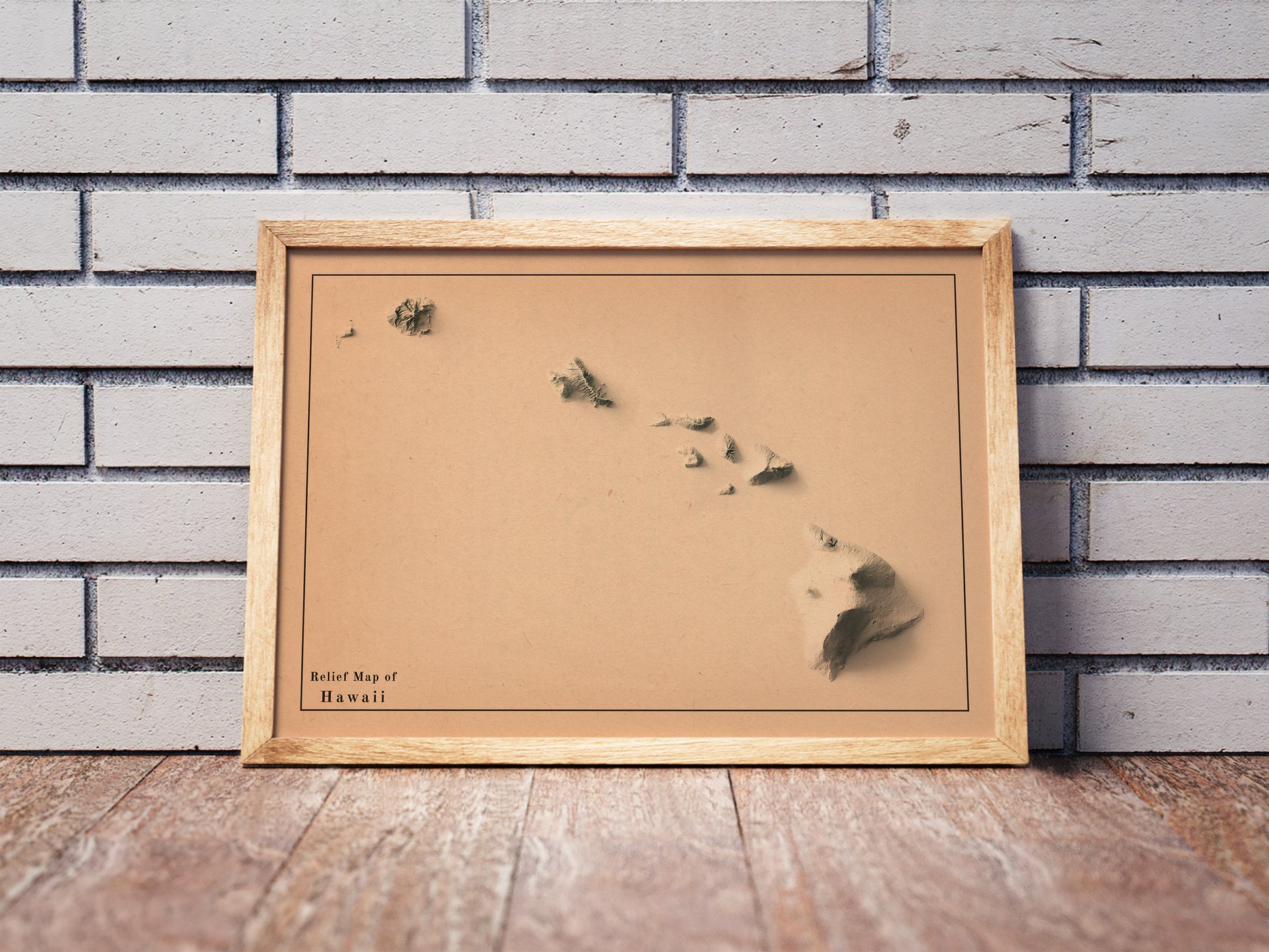 Vintage Hawaii shaded relief map in a wooden frame. Realistic terrain art print for home decor, displayed against a brick wall