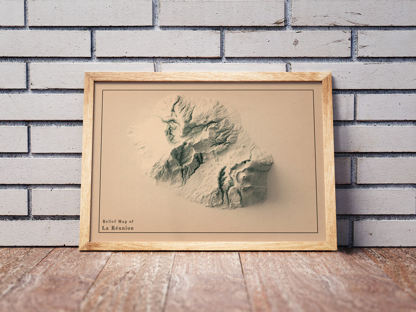 Vintage Reunion, France, shaded relief map in a wooden frame. Realistic terrain art print for home decor, displayed against a brick wall