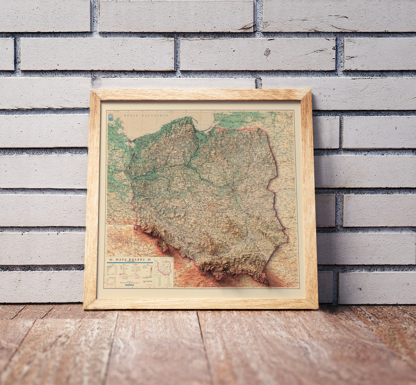 Vintage Poland shaded relief map in a wooden frame. Realistic terrain art print for home decor, displayed against a brick wall