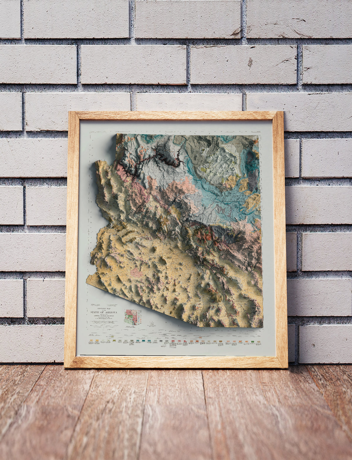 Vintage Arizona Geological shaded relief map in a wooden frame. Realistic terrain art print for home decor, displayed against a brick wall