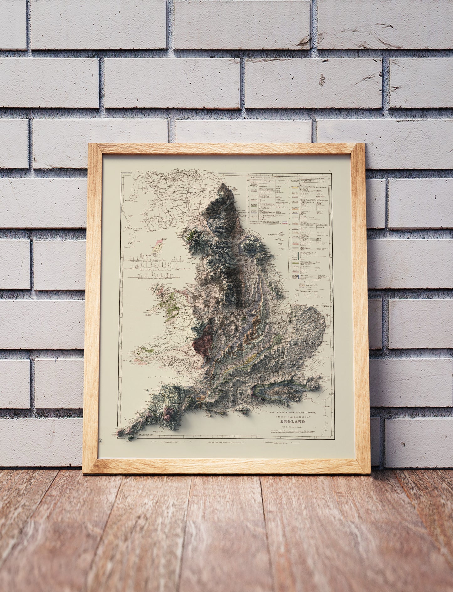 Vintage England shaded relief map in a wooden frame. Realistic terrain art print for home decor, displayed against a brick wall