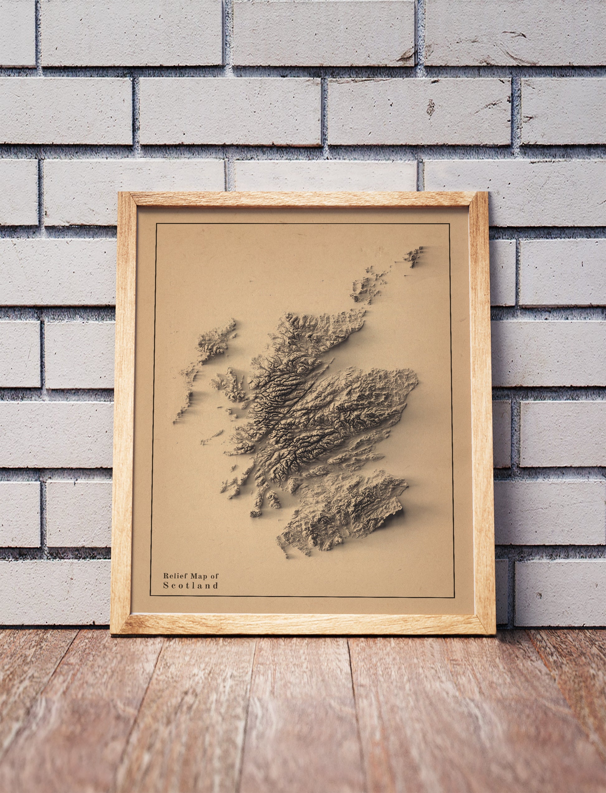Scotland shaded relief map in a wooden frame. Realistic terrain art print for home decor, displayed against a brick wall