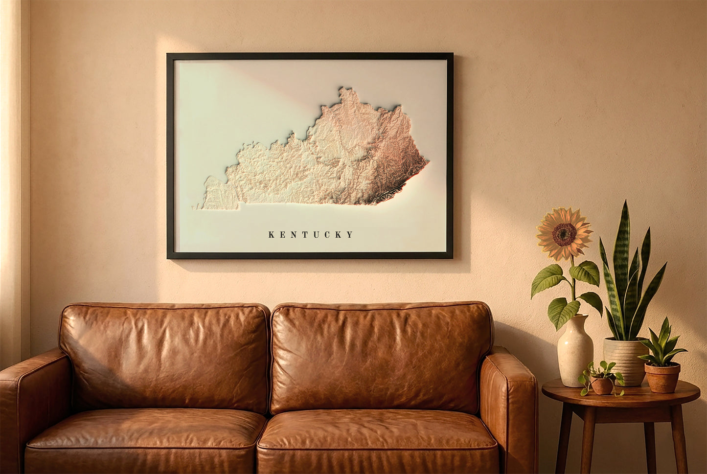 Kentucky relief map in a black frame above a brown leather sofa. Boho living room with warm sunlight, sunflower, and indoor plants on a wooden side table