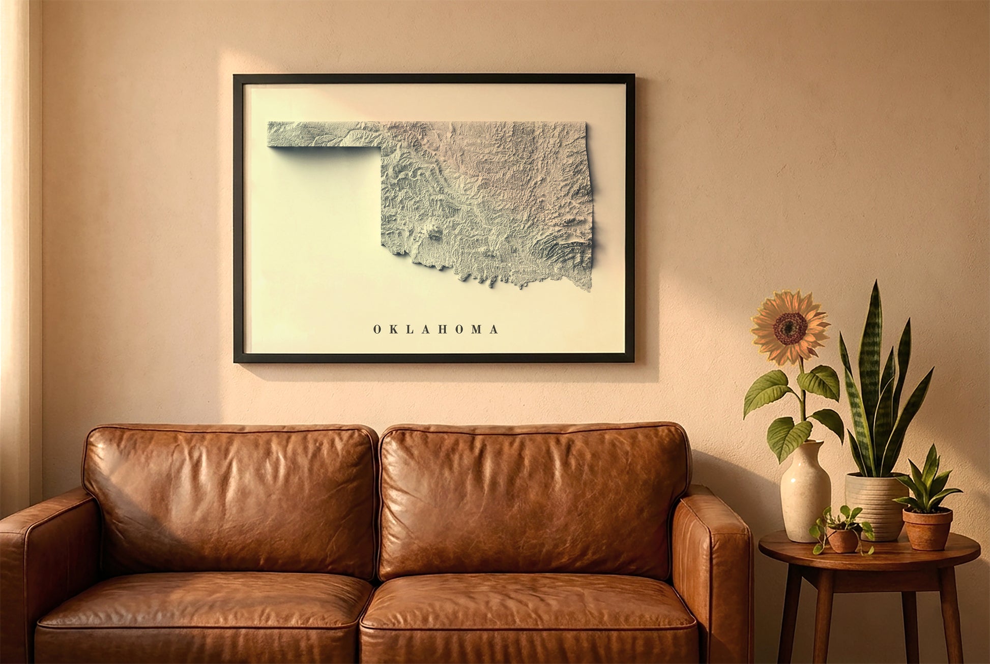 Oklahoma relief map in a black frame above a brown leather sofa. Boho living room with warm sunlight, sunflower, and indoor plants on a wooden side table
