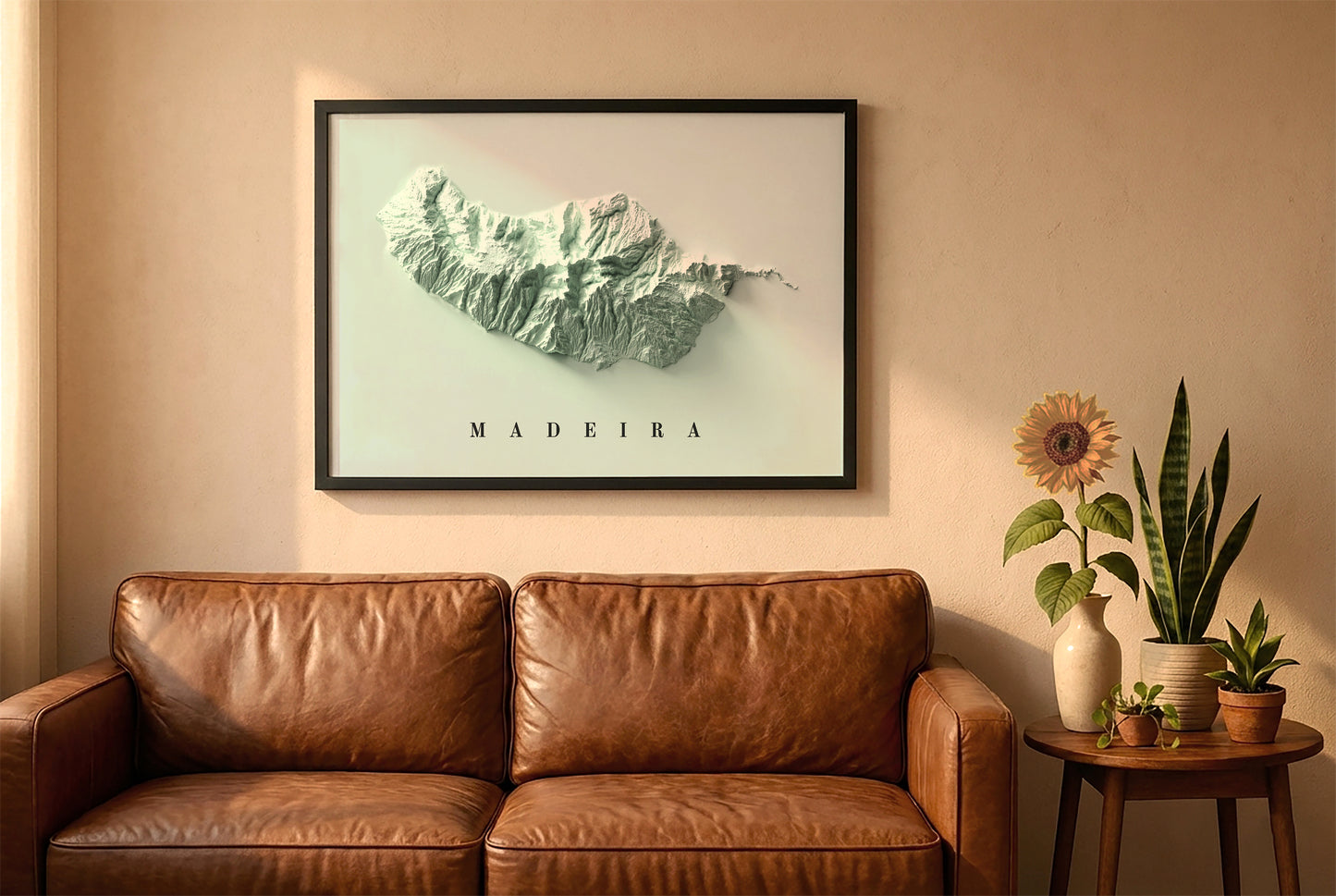 Madeira Island, Portugal, relief map in a black frame above a brown leather sofa. Boho living room with warm sunlight, sunflower, and indoor plants on a wooden side table