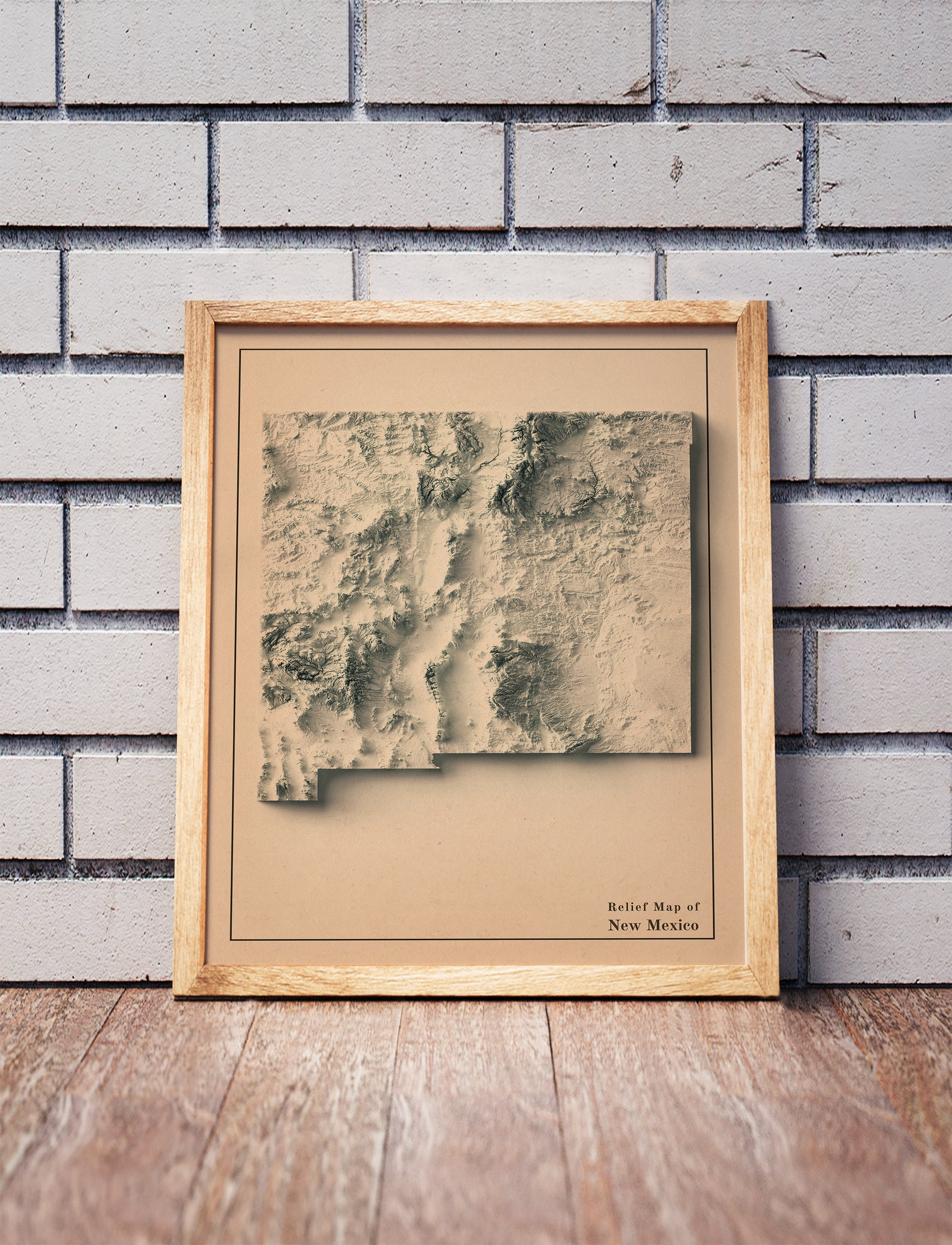 Vintage New Mexico shaded relief map in a wooden frame. Realistic terrain art print for home decor, displayed against a brick wall