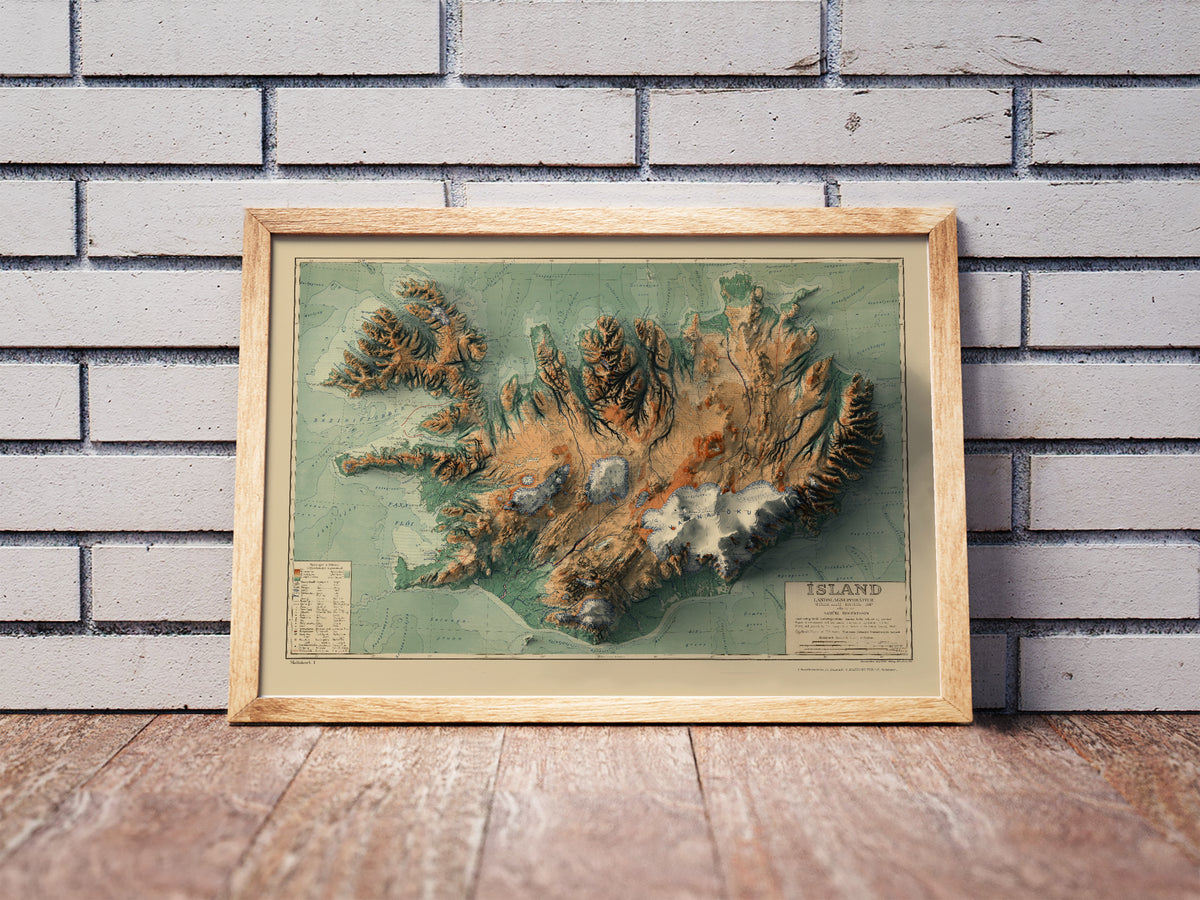 Vintage Iceland shaded relief map in a wooden frame. Realistic terrain art print for home decor, displayed against a brick wall