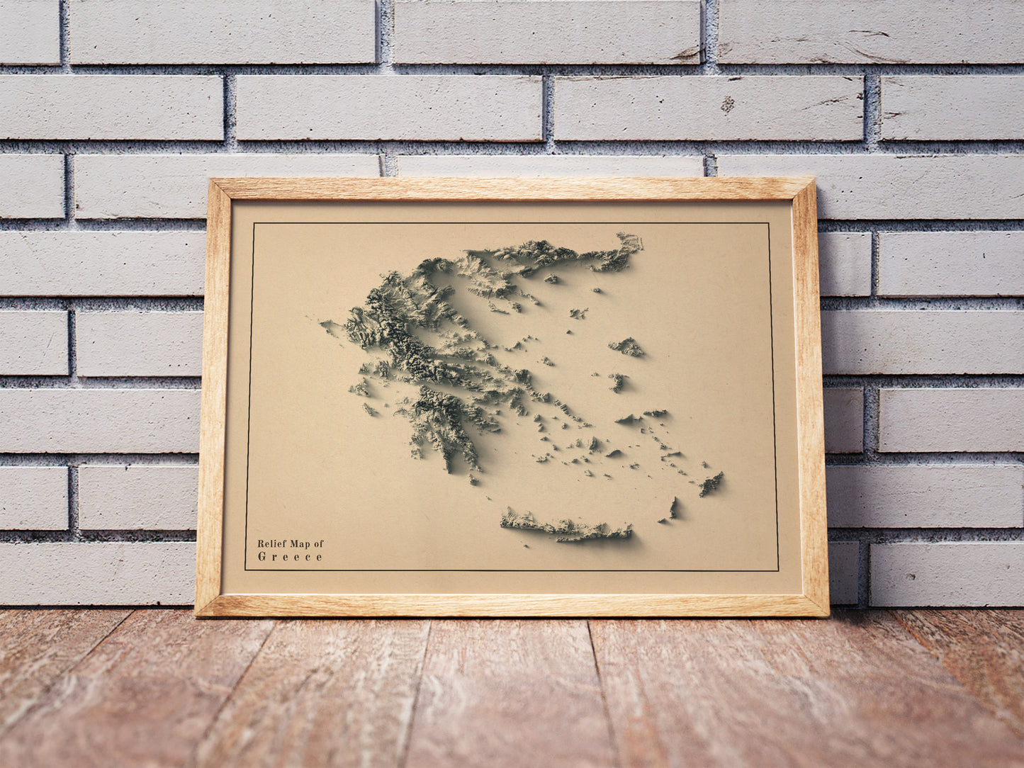 Vintage Greece shaded relief map in a wooden frame. Realistic terrain art print for home decor, displayed against a brick wall