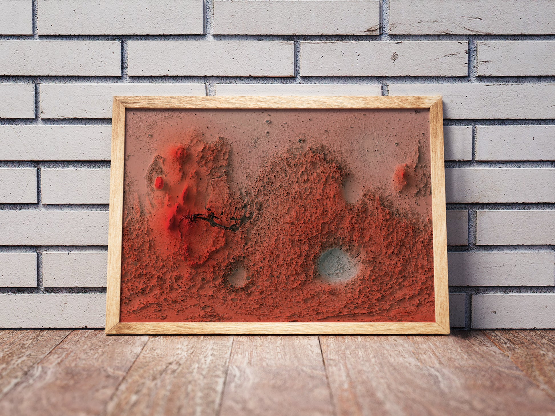 Mars shaded relief map in a wooden frame. Realistic terrain art print for home decor, displayed against a brick wall