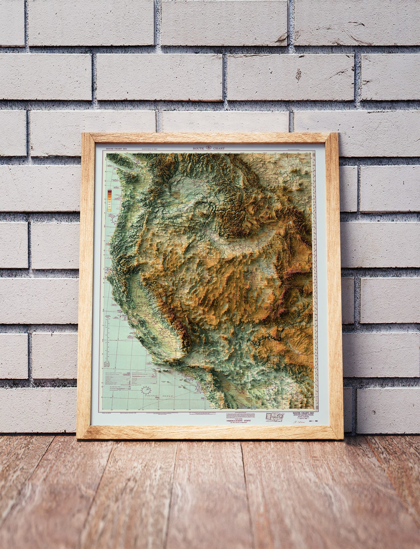 Vintage Western USA shaded relief map in a wooden frame. Realistic terrain art print for home decor, displayed against a brick wall