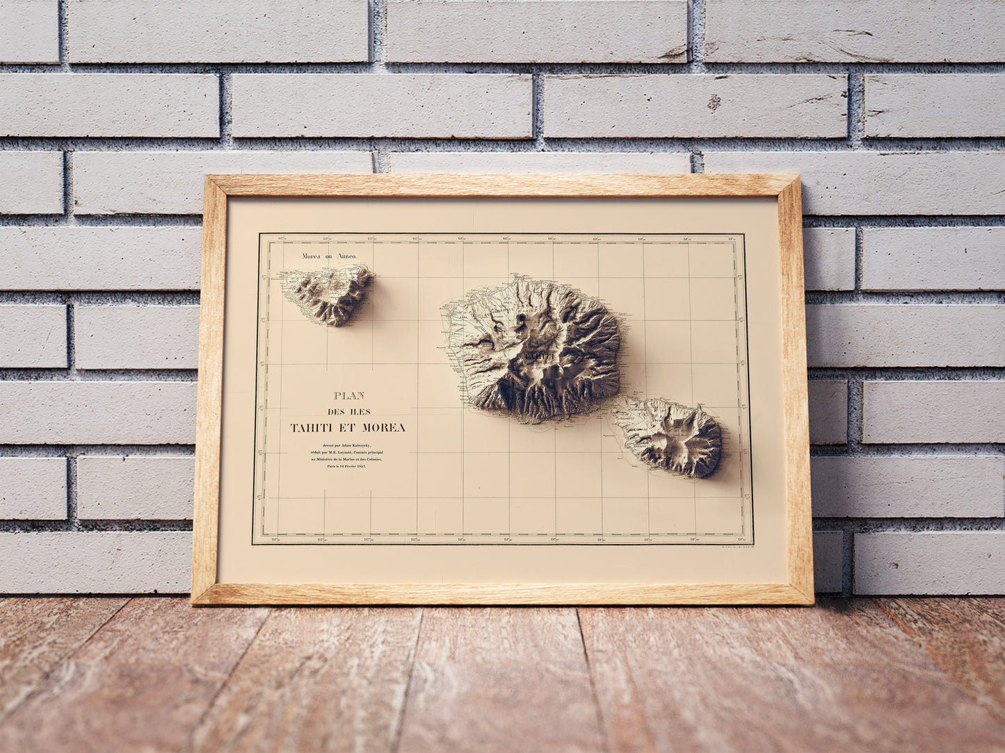 Vintage Tahiti shaded relief map in a wooden frame. Realistic terrain art print for home decor, displayed against a brick wall
