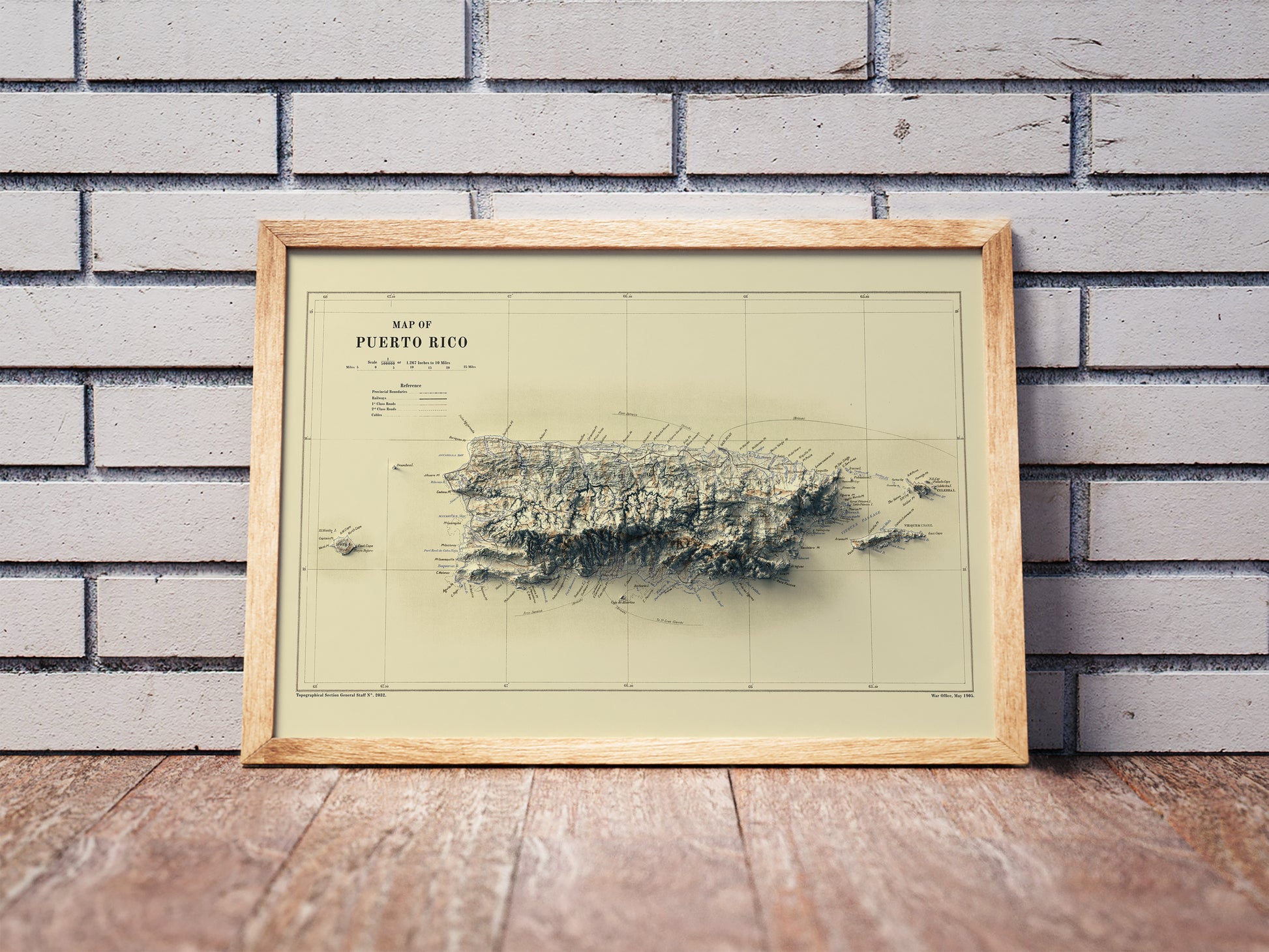 Vintage Puerto Rico shaded relief map in a wooden frame. Realistic terrain art print for home decor, displayed against a brick wall