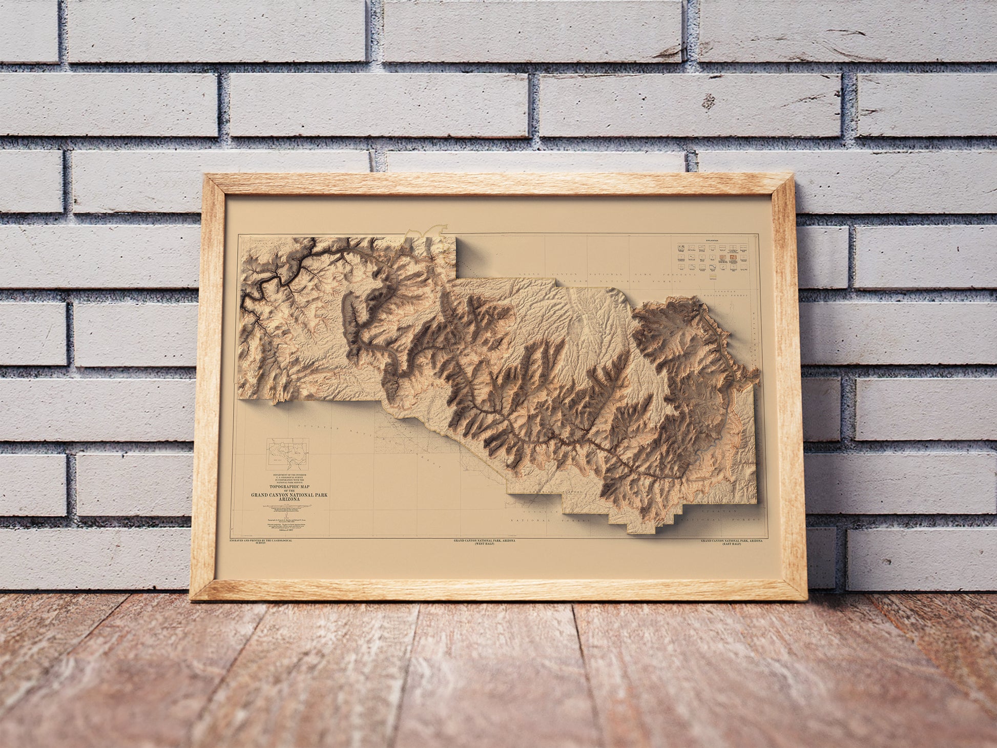 Vintage Grand Canyon shaded relief map in a wooden frame. Realistic terrain art print for home decor, displayed against a brick wall